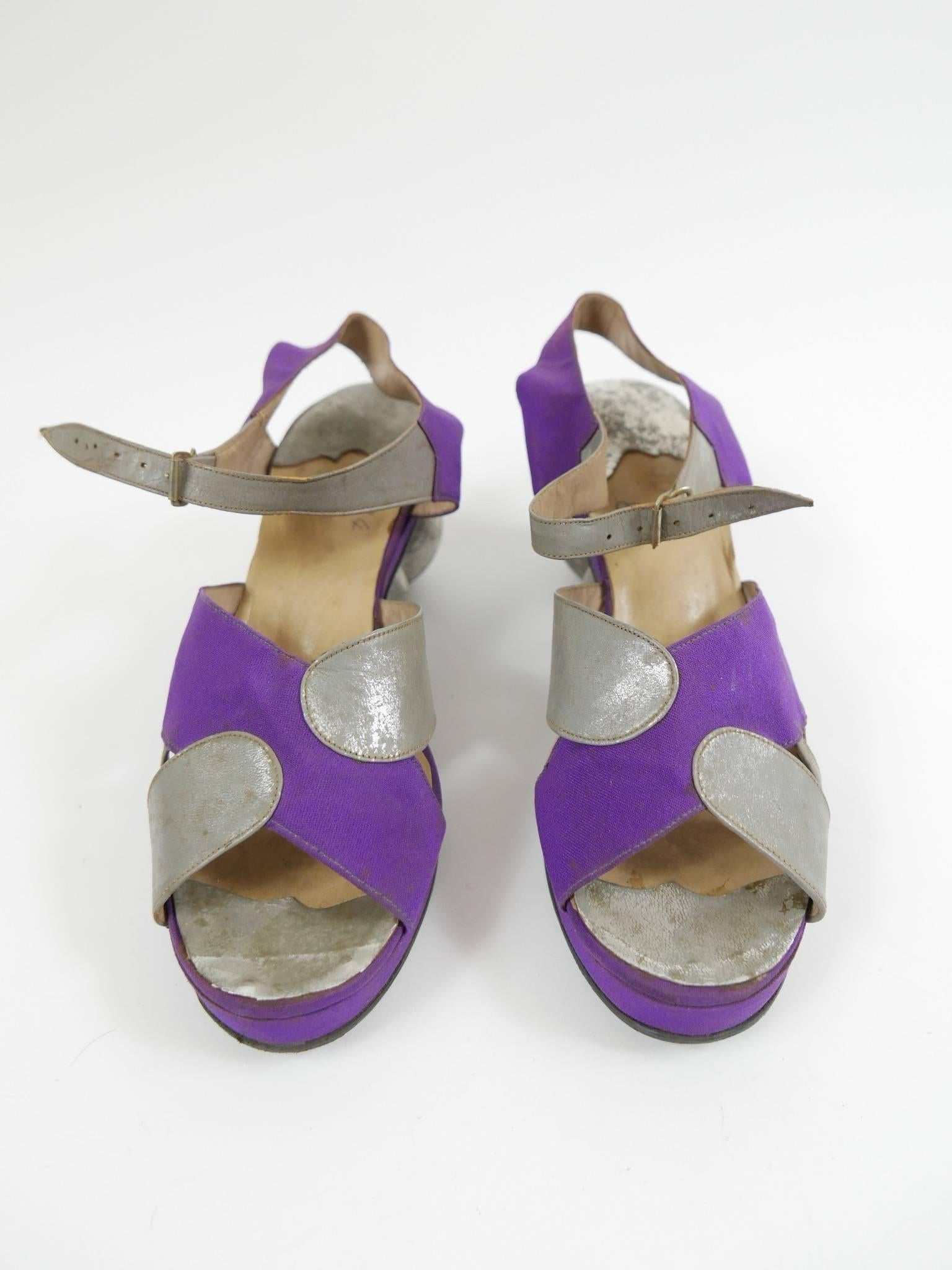 These gorgeous 1940s sandals will add a playful touch to your wardrobe. They are made with a gray silver leather and purple satin. They have gray silver ball wedge and cream leather insole. 

Very good vintage condition 

Brand: N/A
Material:
