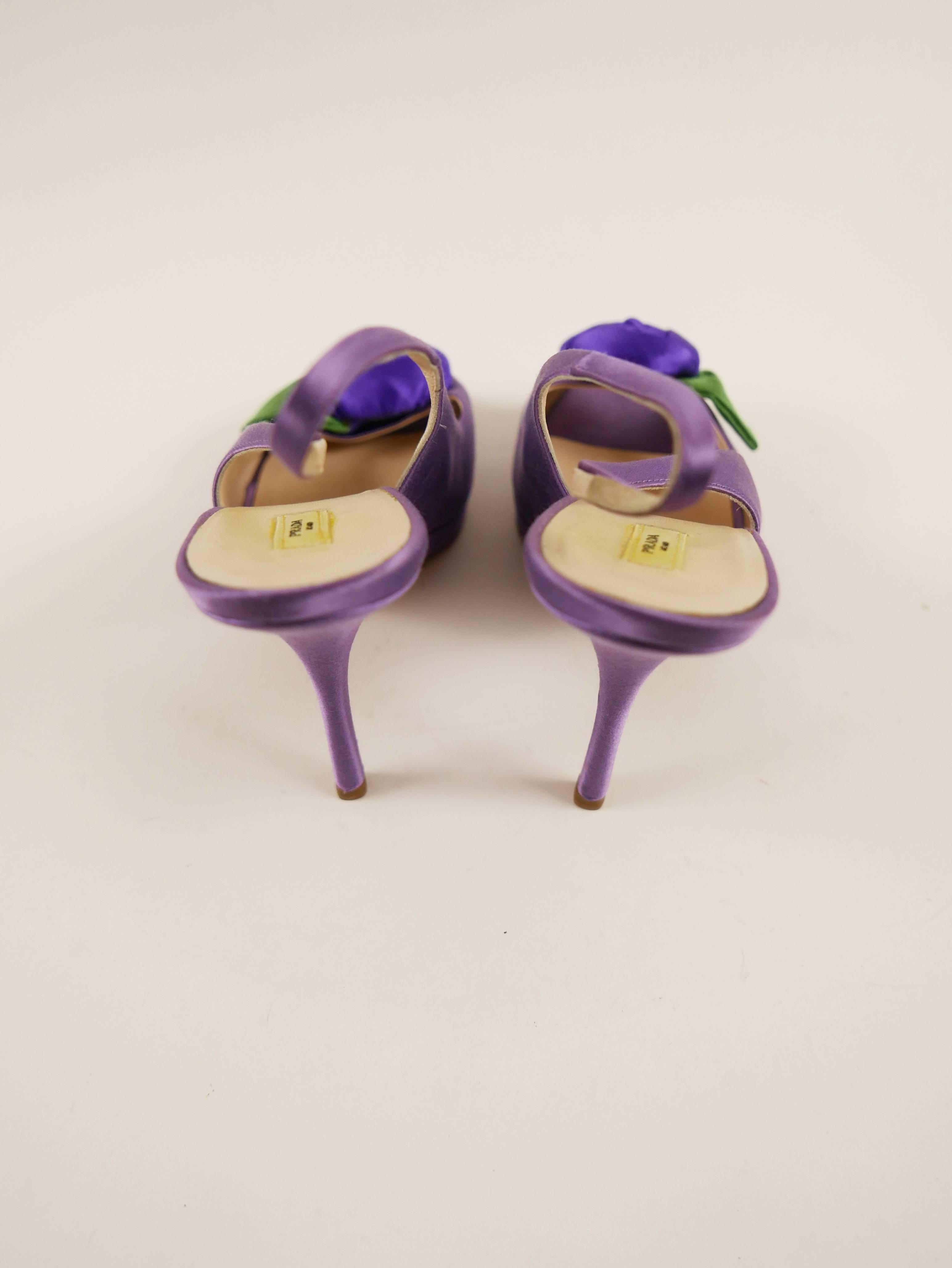 These feminine and authentic Prada pumps shoes are in purple satin and covered with large rose.
They have a classic and sophisticated platform, peep toe and high heels.

Very good condition.

Brand: Prada Milano
Material: silk/leather
Color: