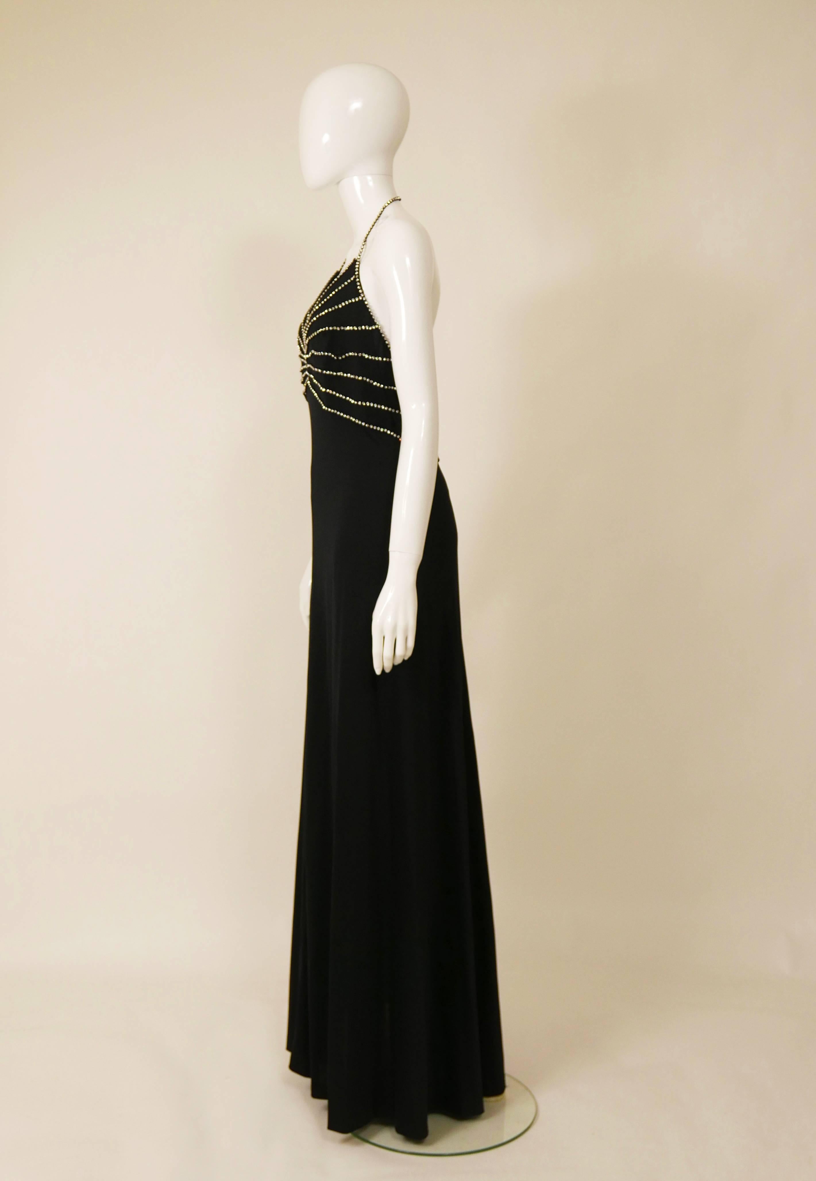 This lovely 1970s Azzaro halter top long dress is in black jersey fabric with rhinestones details. It has spaghetti straps and soft line with back zip closure. 

Very good vintage condition

Label: Loris Azzaro Paris Made in France
Fabric: