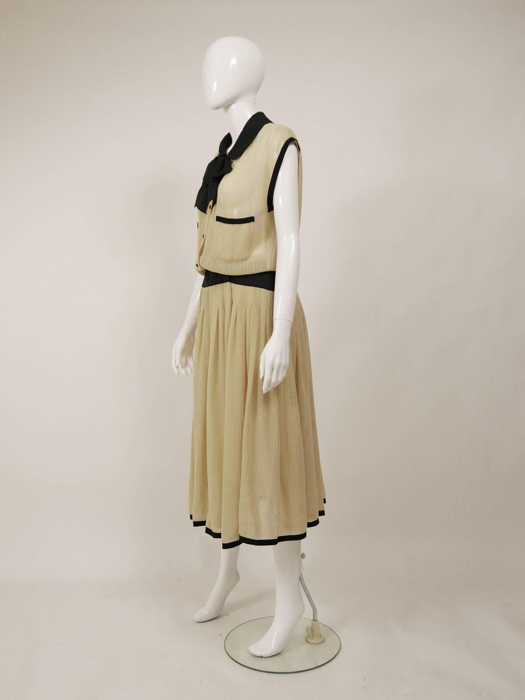 This lovely Chanel day dress is in a cream knitted woolen fabric with black satin details. It has buttons closure and hooks on the waistband.

Very good vintage condition 

Label: Chanel Boutique
Fabric: wool/silk
Color: