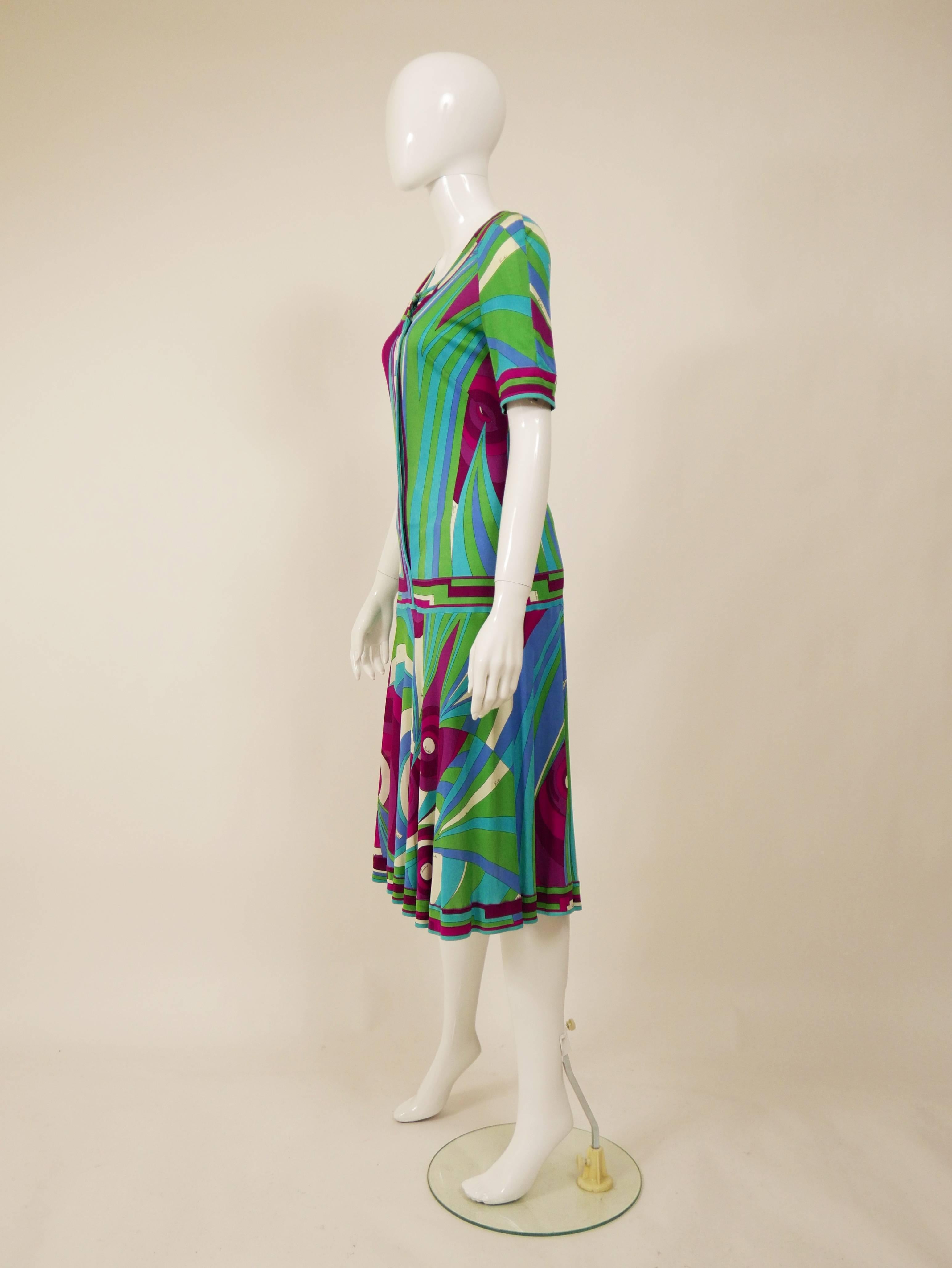 This lovely Emilio Pucci 1970s dress is in a colourful silk jersey with typical exotic and colorful Pucci abstract print with signed Emilio fabric. It has round neckline, short sleeves, low waist and zip closure at the front.

Good vintage