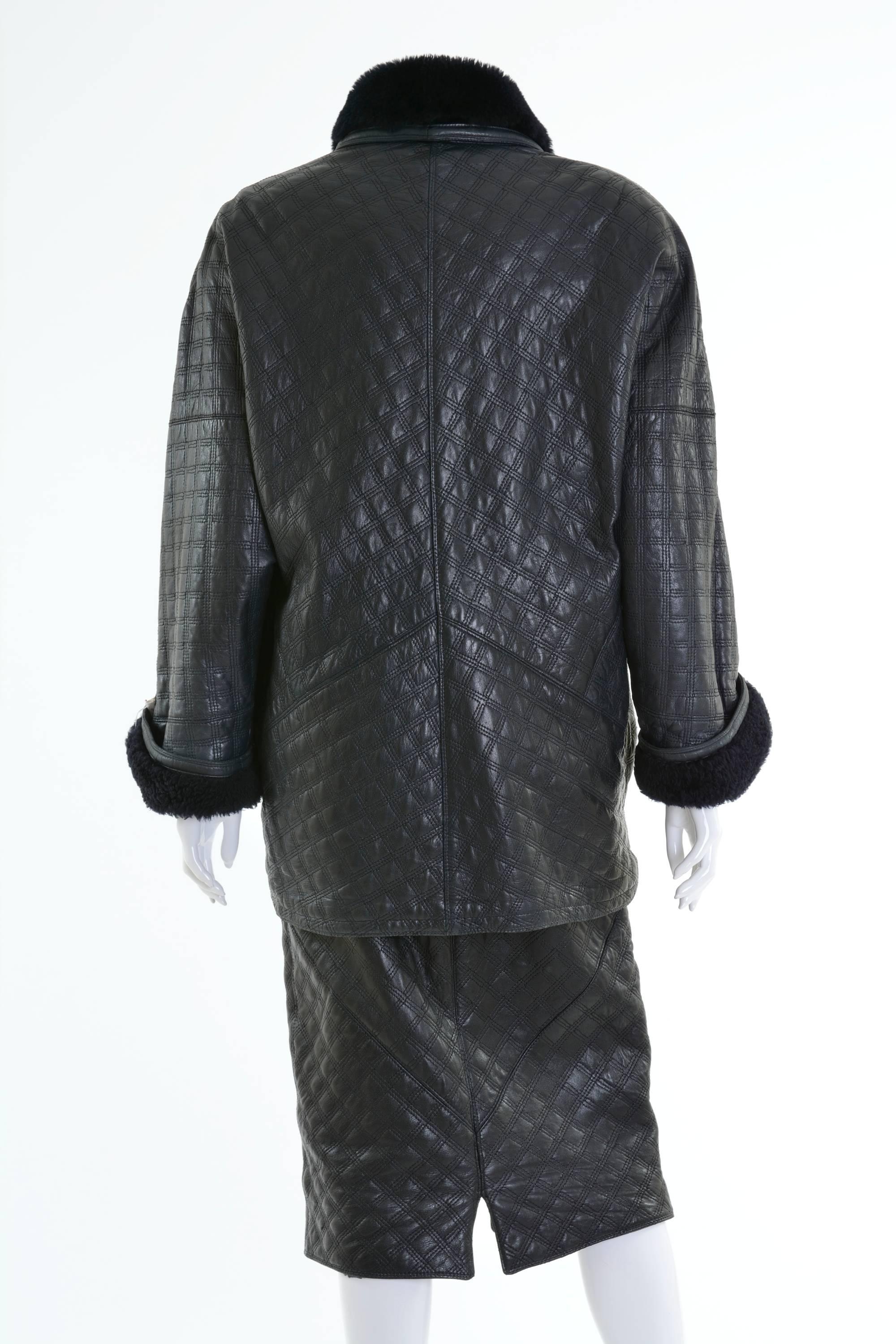 This awesome Gianni Versace suit dress is in a black soft quilted leather and sheepskin. The jacket has oversize line, dolman sleeves, padded shoulder and asymmetric closure, two side pockets and is lined with black warm woolen fabric. The skirt has