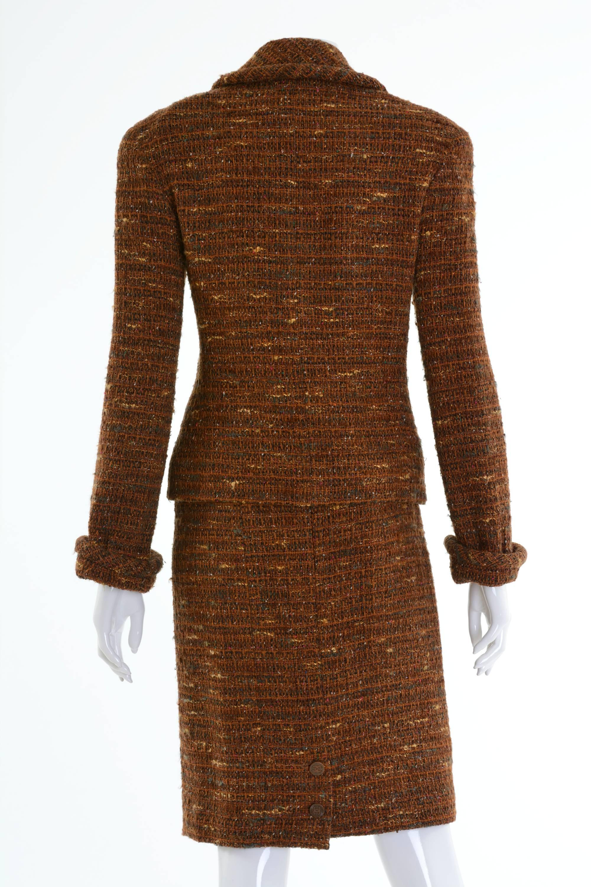 This adorable and authentic Chanel suit dress is in a brown salt and pepper boucle wool fabric. The jacket has shoulder pads, two front little pockets and closing with CC logo copper metal buttons. The pencil skirt has back zip closure with hook.