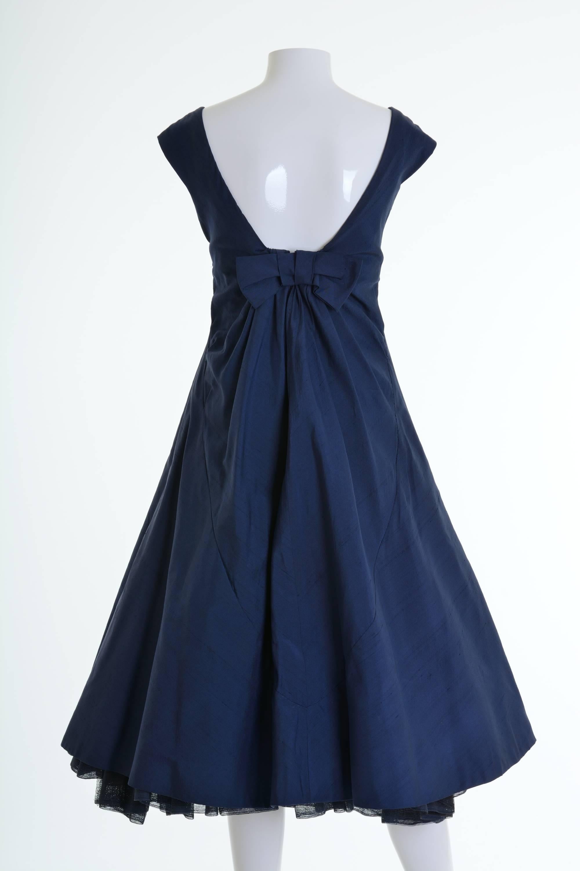 This amazing 1950s cocktail dress is in a blue silk taffeta fabric. It has full pleateds circle skirt with crinoline petticoat and boning corset inside. It has back double zip closure and hooks.

Giuseppina Tizzoni born in 1889. He opened his own