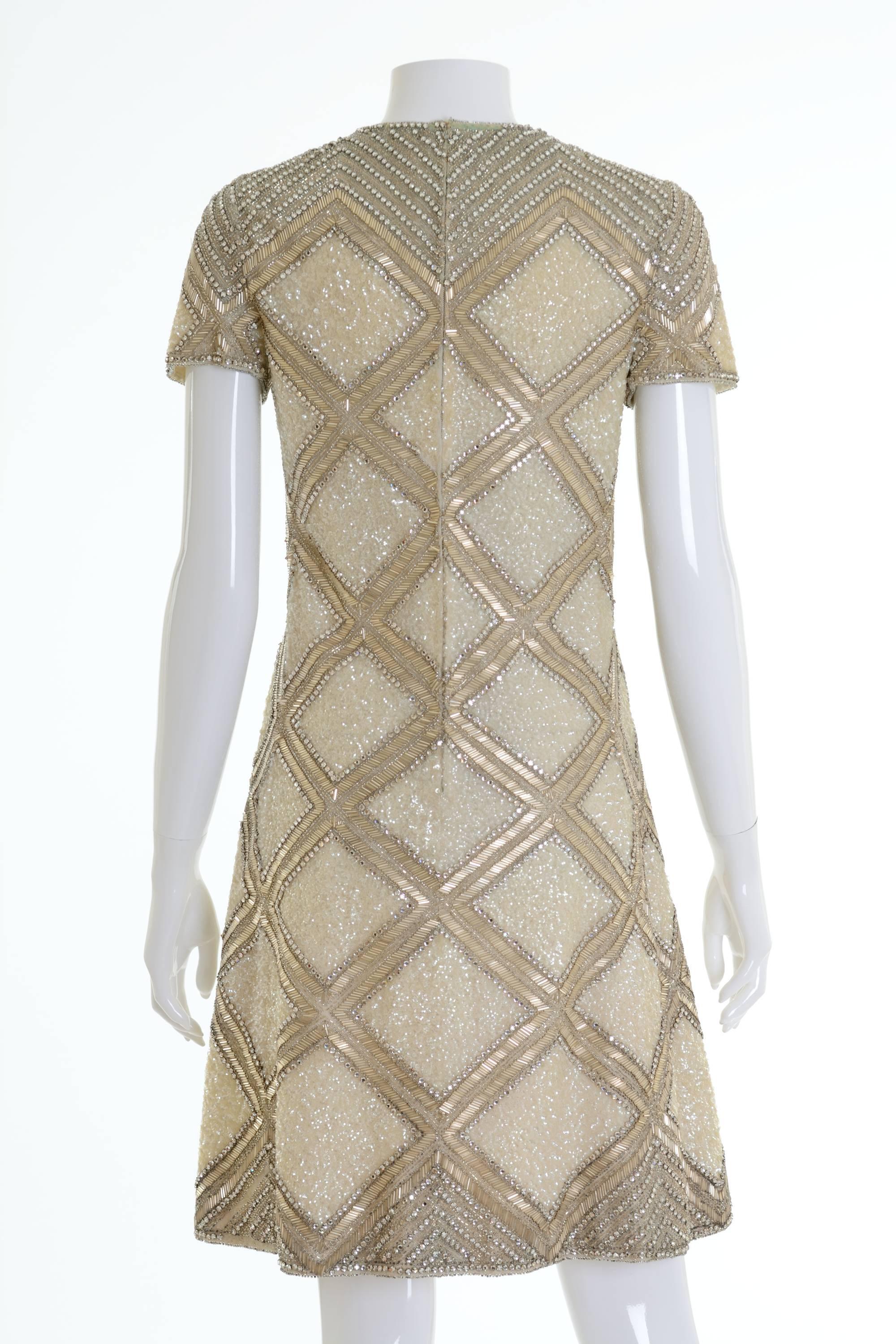 This amazing 1960s Mila Schön cocktail dress is in a fabulous silver tone sequins, rhinestones and glass beaded fabric. It's very heavy fabric and has back zip closure and is fully lined. 

Good vintage condition

Label: Mila Schön - Made in