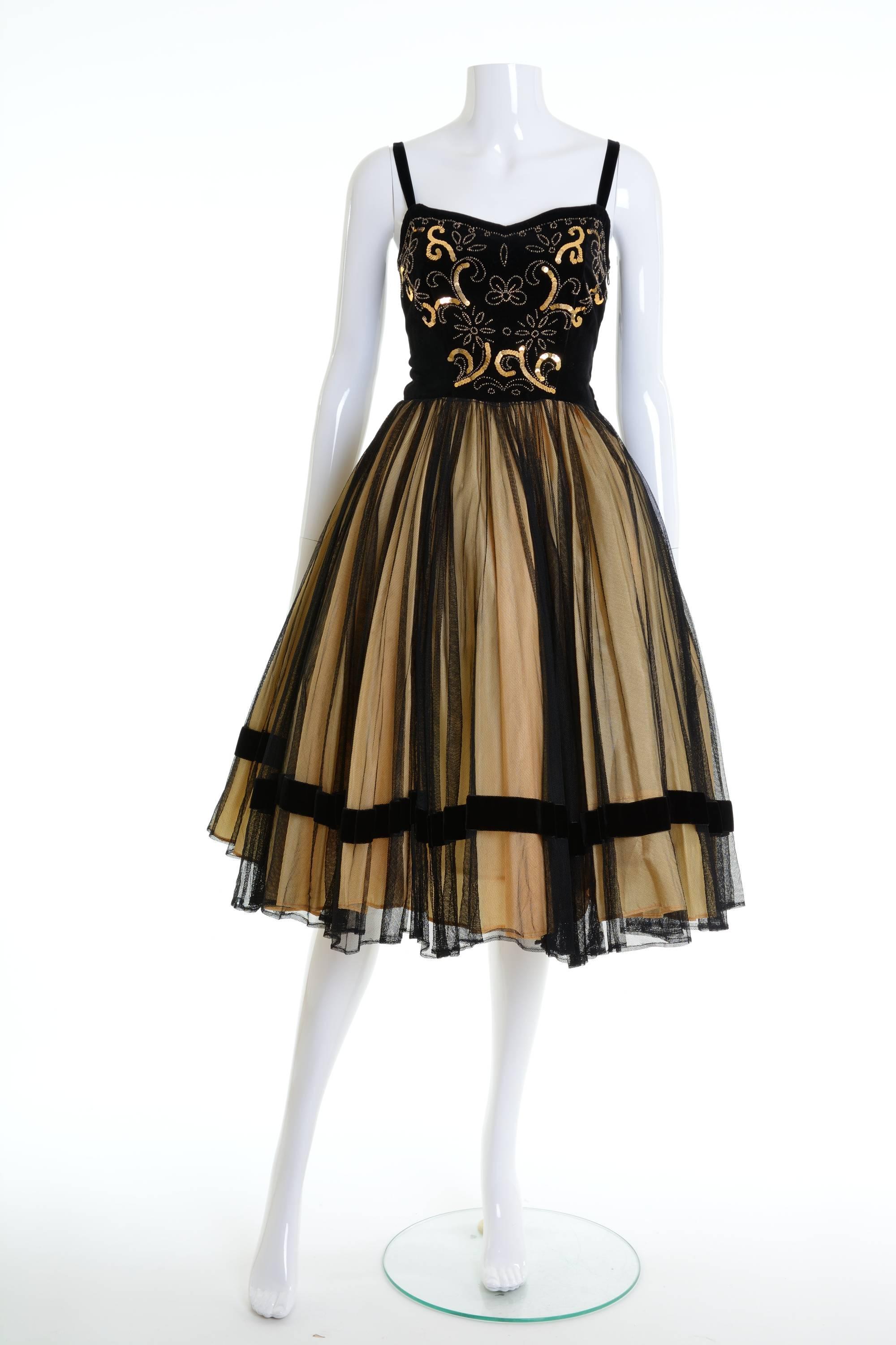 This gorgeous 1950s dress is in a black velvet and tulle fabric with amazing golden sequins and beadeds embroidered. It has a full circle skirt and side zip closure. It's fully lined. 

Good vintage condition
 
Label: N/A
Fabric: silk/nylon
Color: