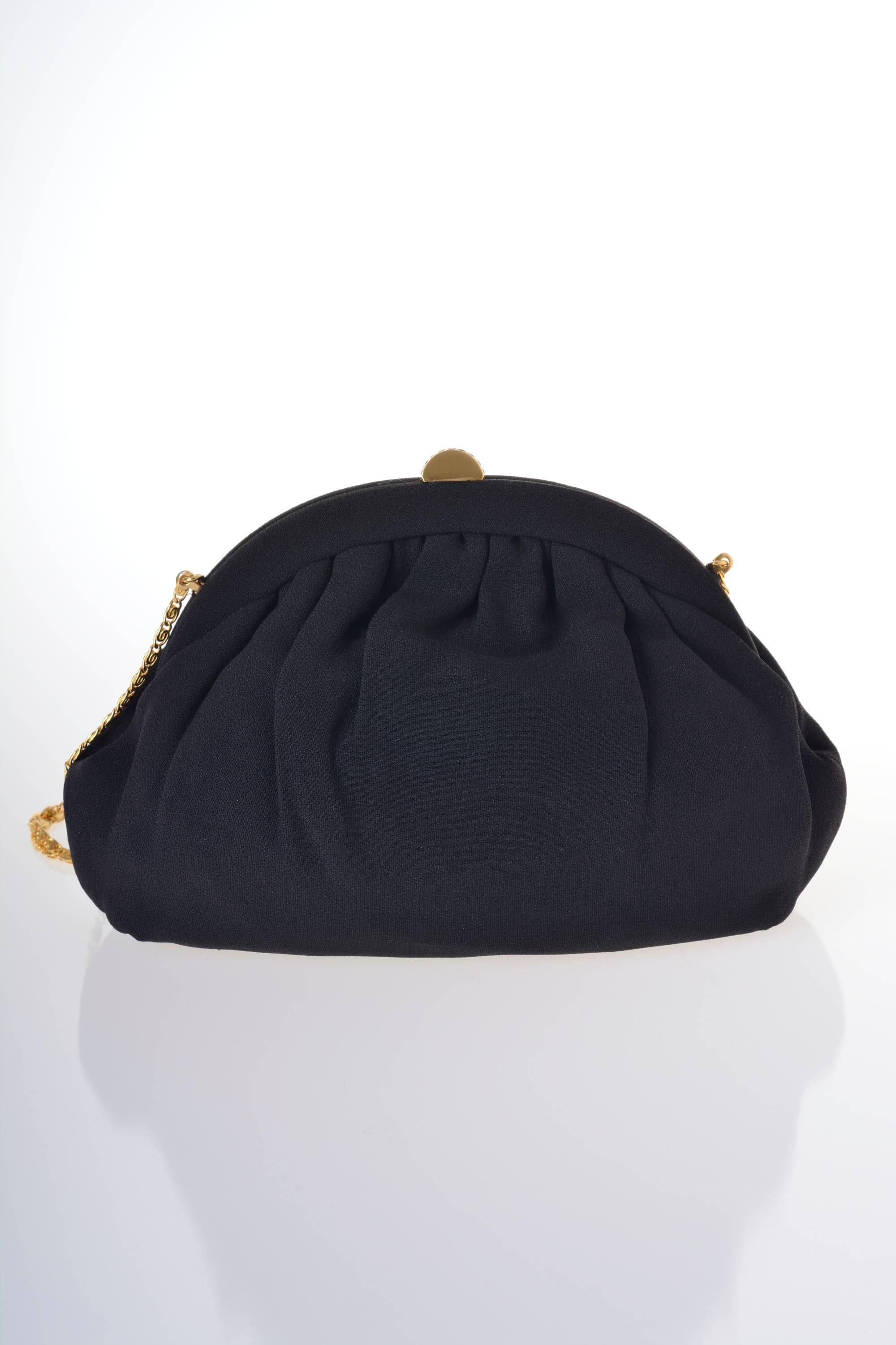 This gorgeous 1950s evening bag is in black silk crepe fabric. It has golden tone metal closure and long chain, is lined with cream satin and has a little pocket inside.

Good vintage condition

Measurements: 
Width 10 inch
Height 7 inch
Depth 3