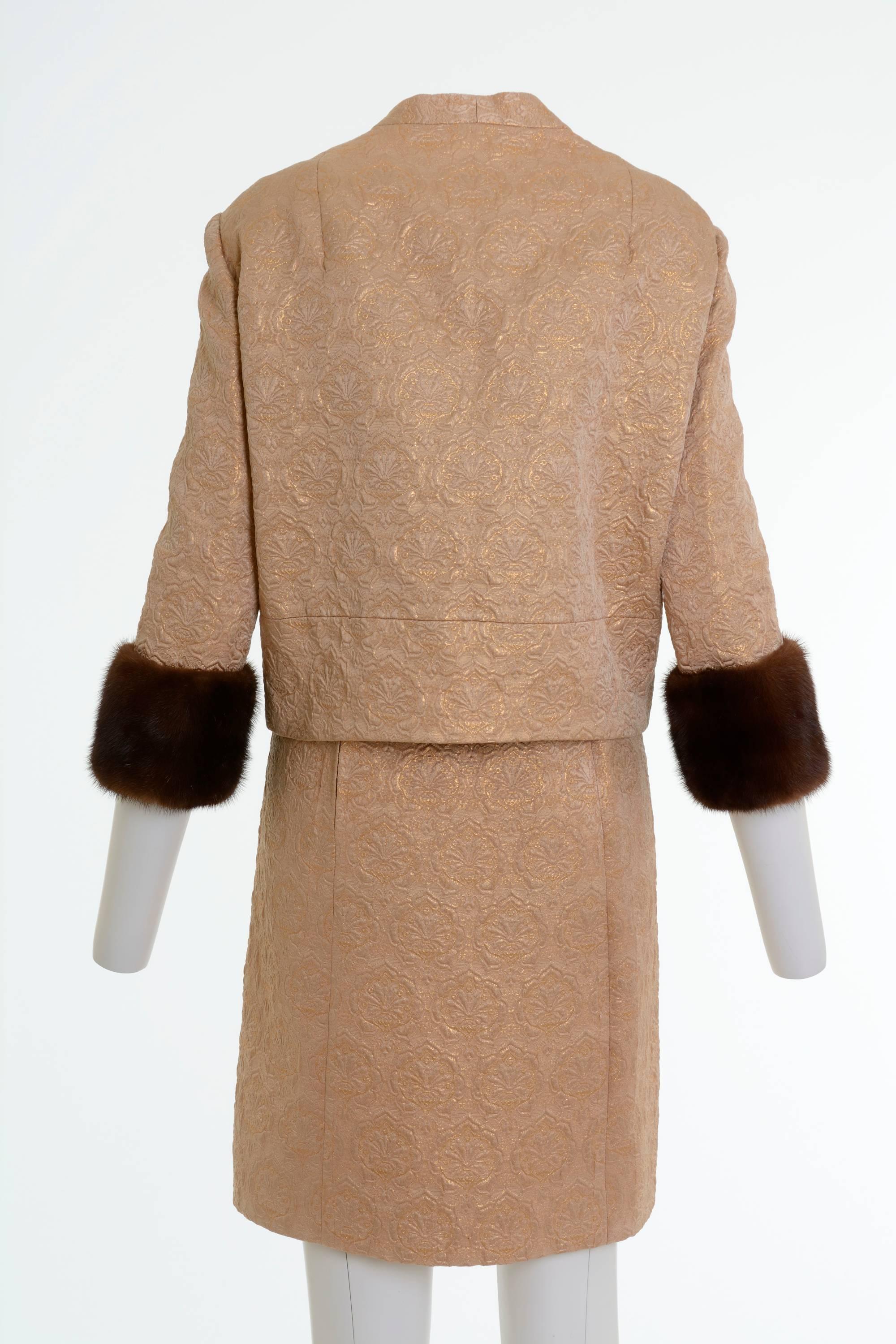 This charming early 1960s cocktail suit dress is in a golden lurex brocade fabric. The  sleeveless dress has side back zip closure. The jacket has mandarin collar, large lovely buttons closure and embellished with brown mink fur trimmings. It's