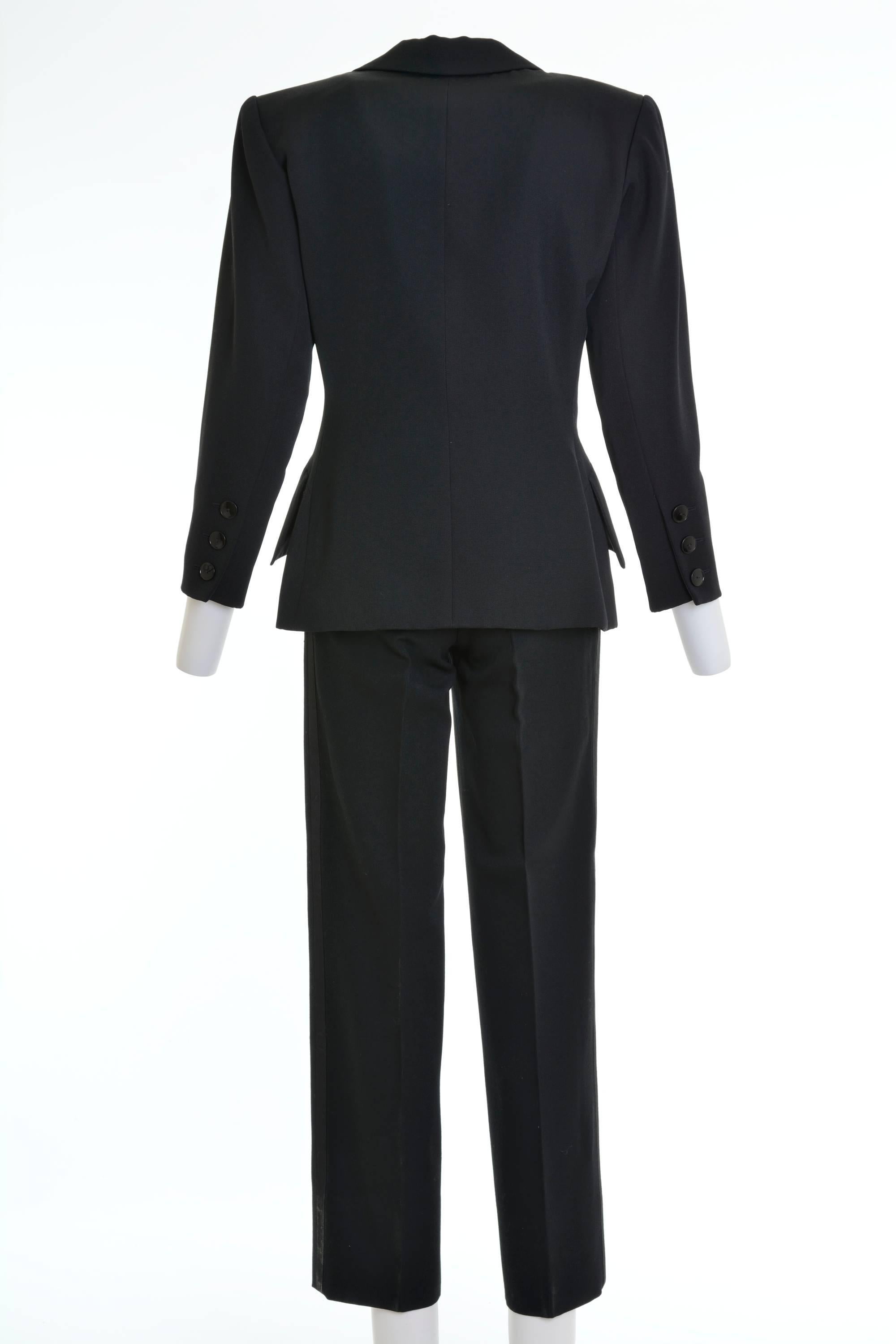 Tuxedo jacket, two jetted pockets with flap, one welt left pocket, plain cuff, two spare buttons in the inside, polyester satin revers opening tuxedo pants, front and back pleats, side pockets.
It has a lot of fabric in the hem of the pants, to be