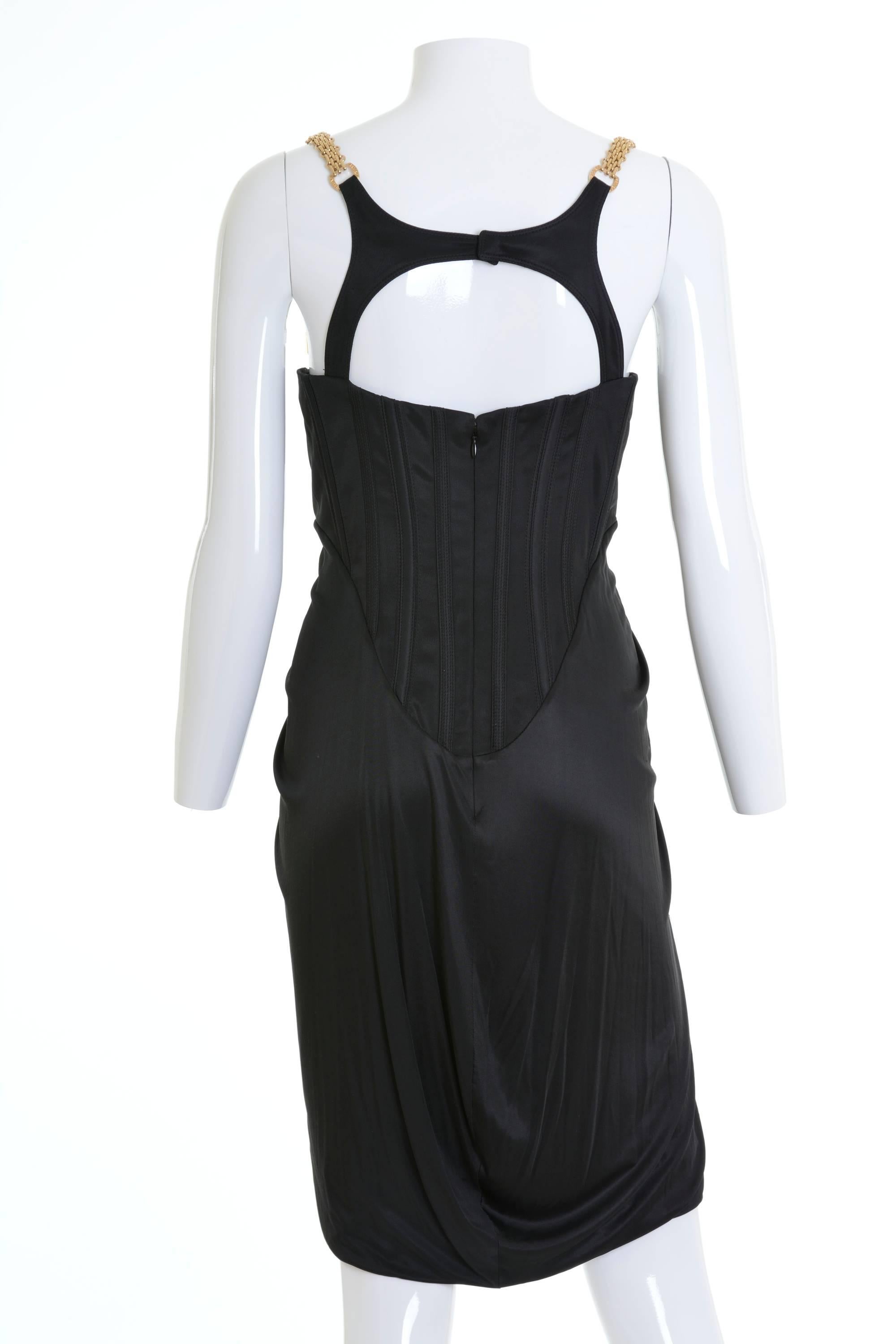Gianni Versace bustier dress in black rayon fabric with gold cable chain strap and back opening. Empire line, top-stitches, boning bodice, with back zip closure and Versace metail details. 

Good Condition

Label: Gianni Versace 
Fabric: 99% Rayon