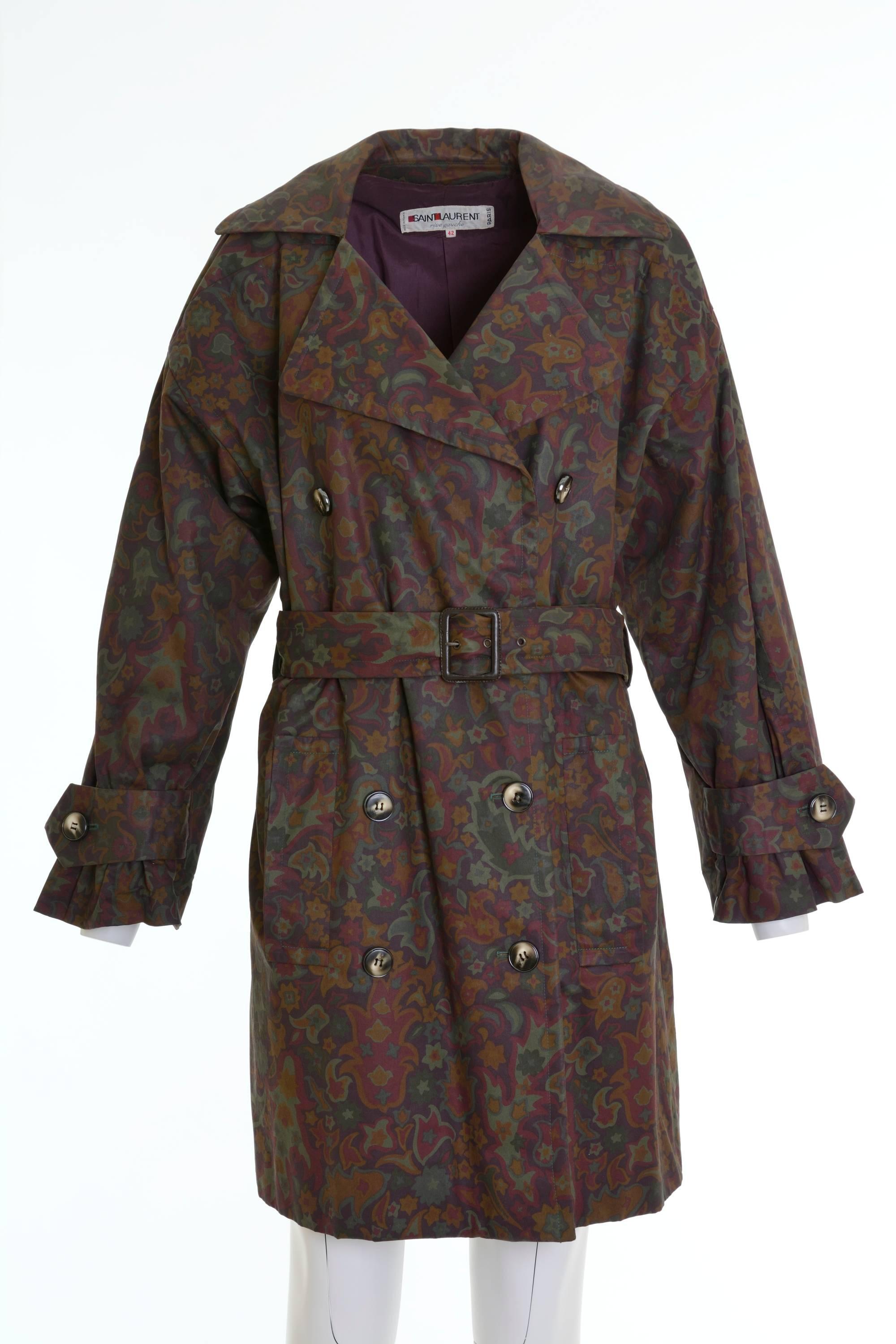 This lovely 1980s Yves Saint Laurent trench coat is in a purple and green floral print gabardine cotton waterproof fabric. It's oversize and has metal buttons, two side pockets and is purple satin lined. It's included the belt. 

Good vintage