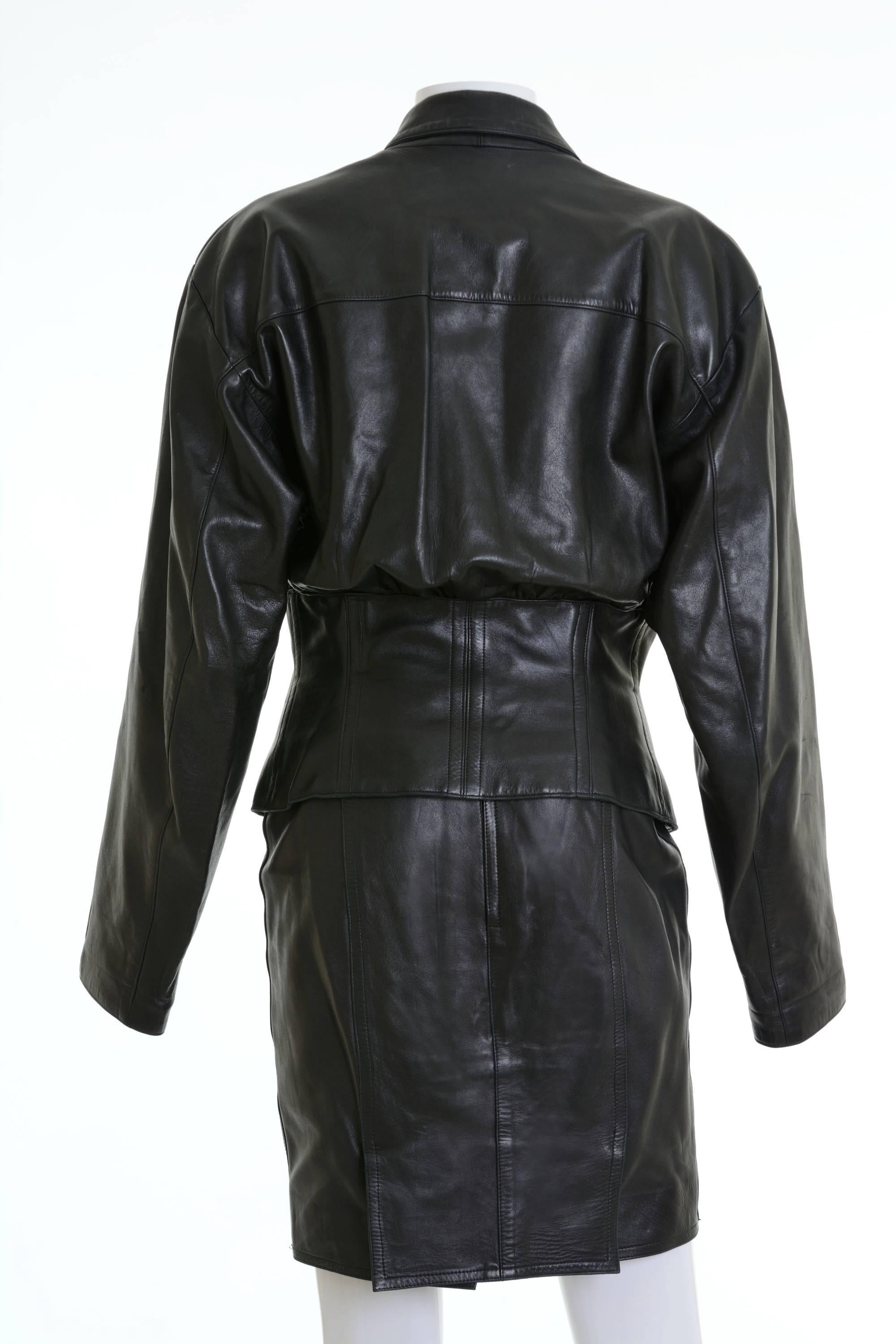 1980s Alaïa Jacket & Skirt in a black leather fabric, fully lined in a acetate fabric, double-breasted closure jacket, framed lapel, buttons closure, waist cincher shape, left breast welt. Pencil skirt with back zip closure and snap, double kick