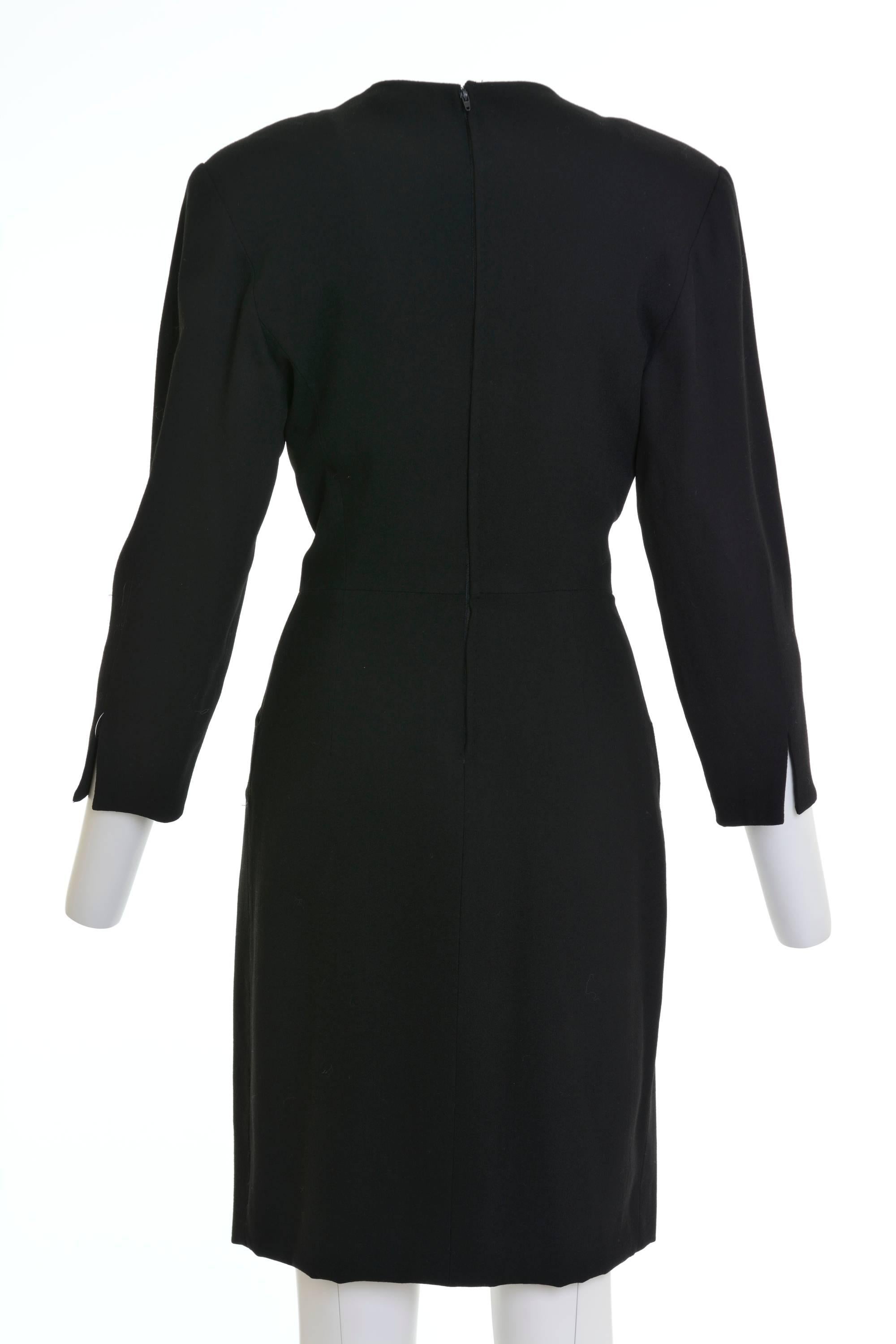 This lovely Gianfranco Ferrè day dress is in a black woolen fabric with decorative jewelry buttons. It has long sleeves, slightly padded shoulder, two side pockets, back zip and hook closure and is fully satin lined.

Good vintage