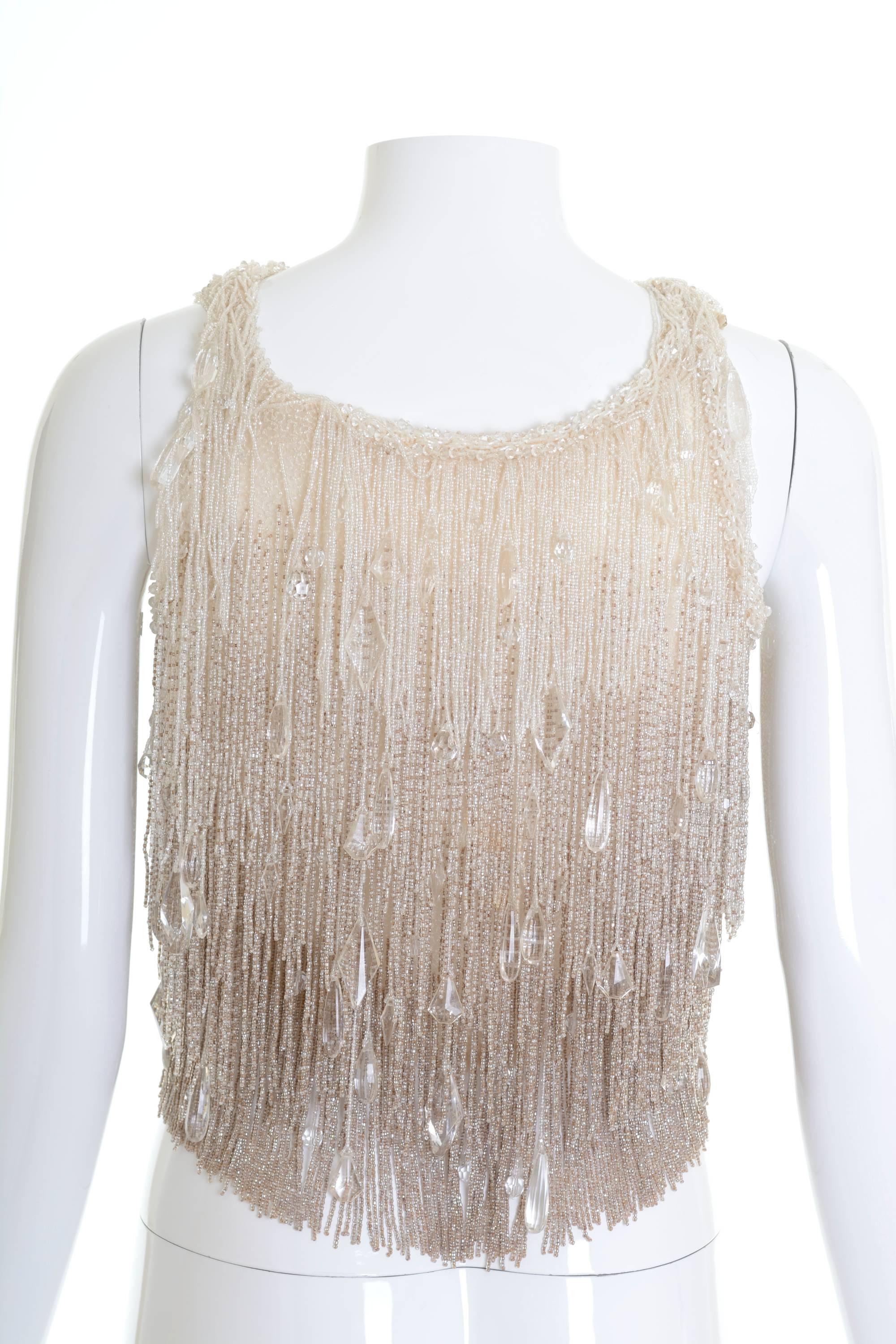 This amazing 1920s top is in a fabulous cream shades silk fabric with amazing heavily glass beadeds fringes. It has side snaps closure and is fully lined.

Good vintage condition

Label: N/A
Fabric: silk/beadeds
Color: cream

Measurement:
Estimeted