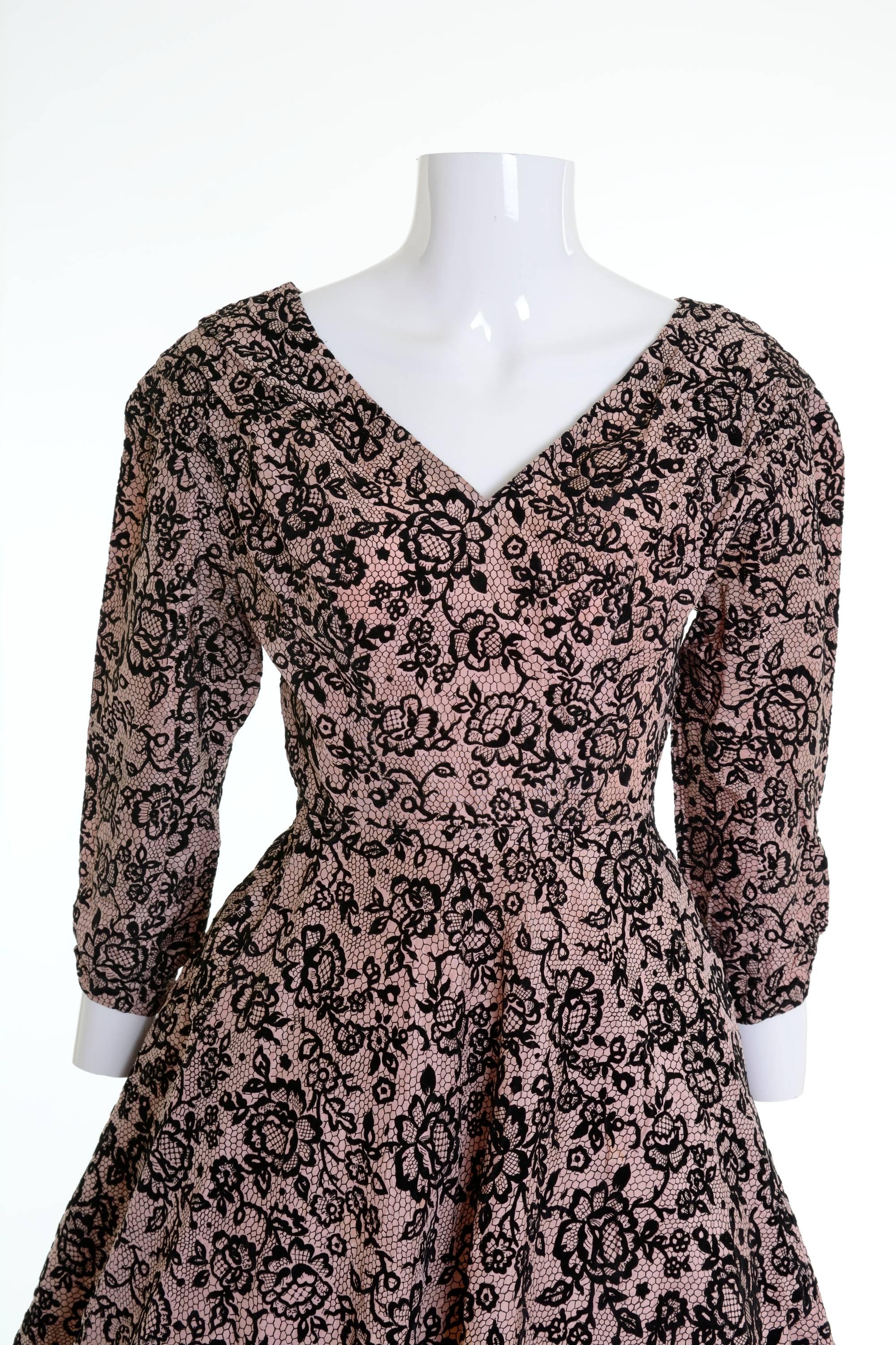 This lovely 1950s dress is in a powder pink with black velvet brocade floral print  fabric. It has 3/4 sleeve, full circle skirt and side zip closure.

Good vintage condition
 
Label: N/A
Fabric: acetate
Color: black/powder
