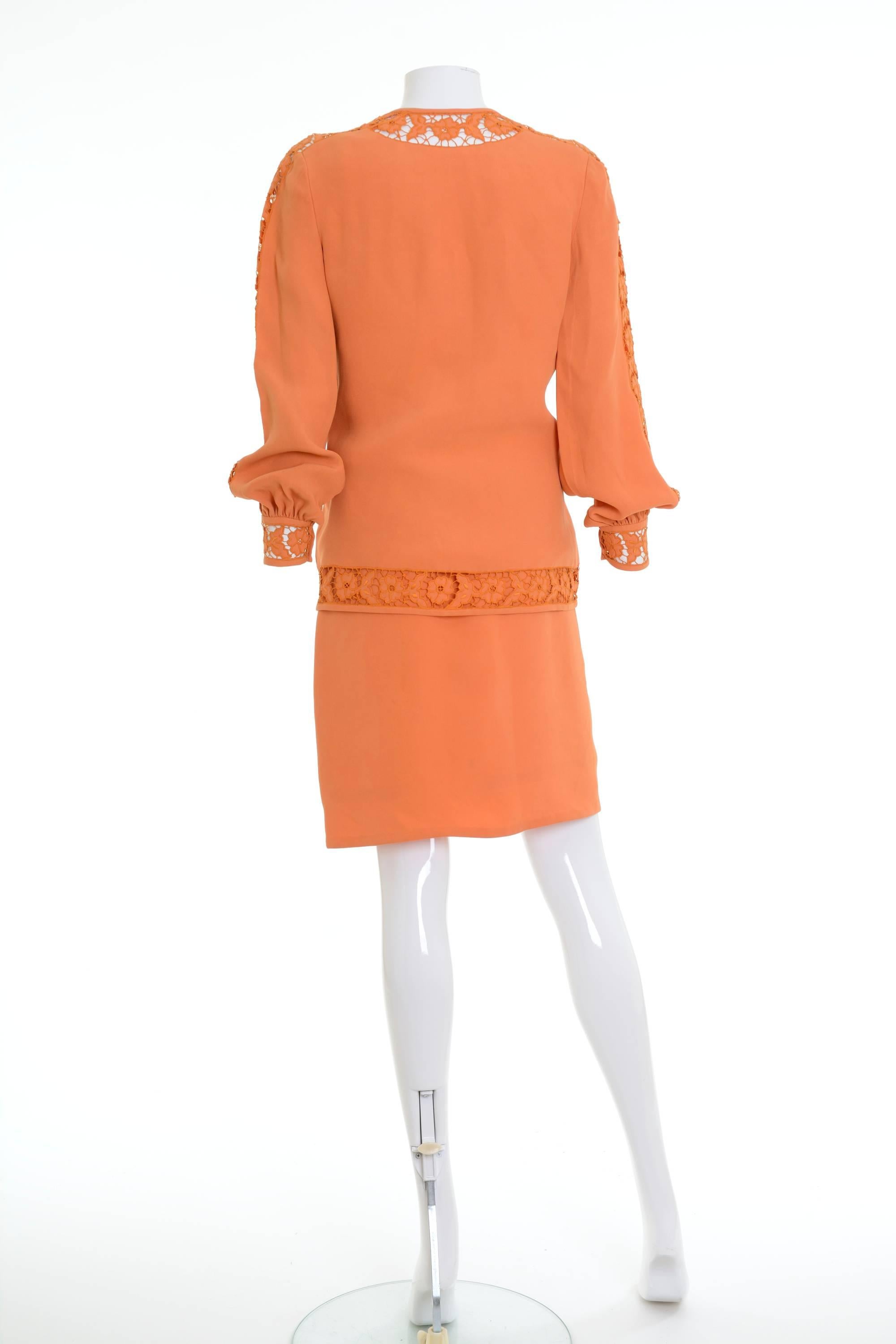 Late 1970s Lancetti skirt suit with top in a orange silk fabric. Jacket with hook and eye closure, cutwork embroidery around the edges and the cuffs. Top with cutwork embroidery, spaghetti straps and side zip closure. Fully lined skirt with