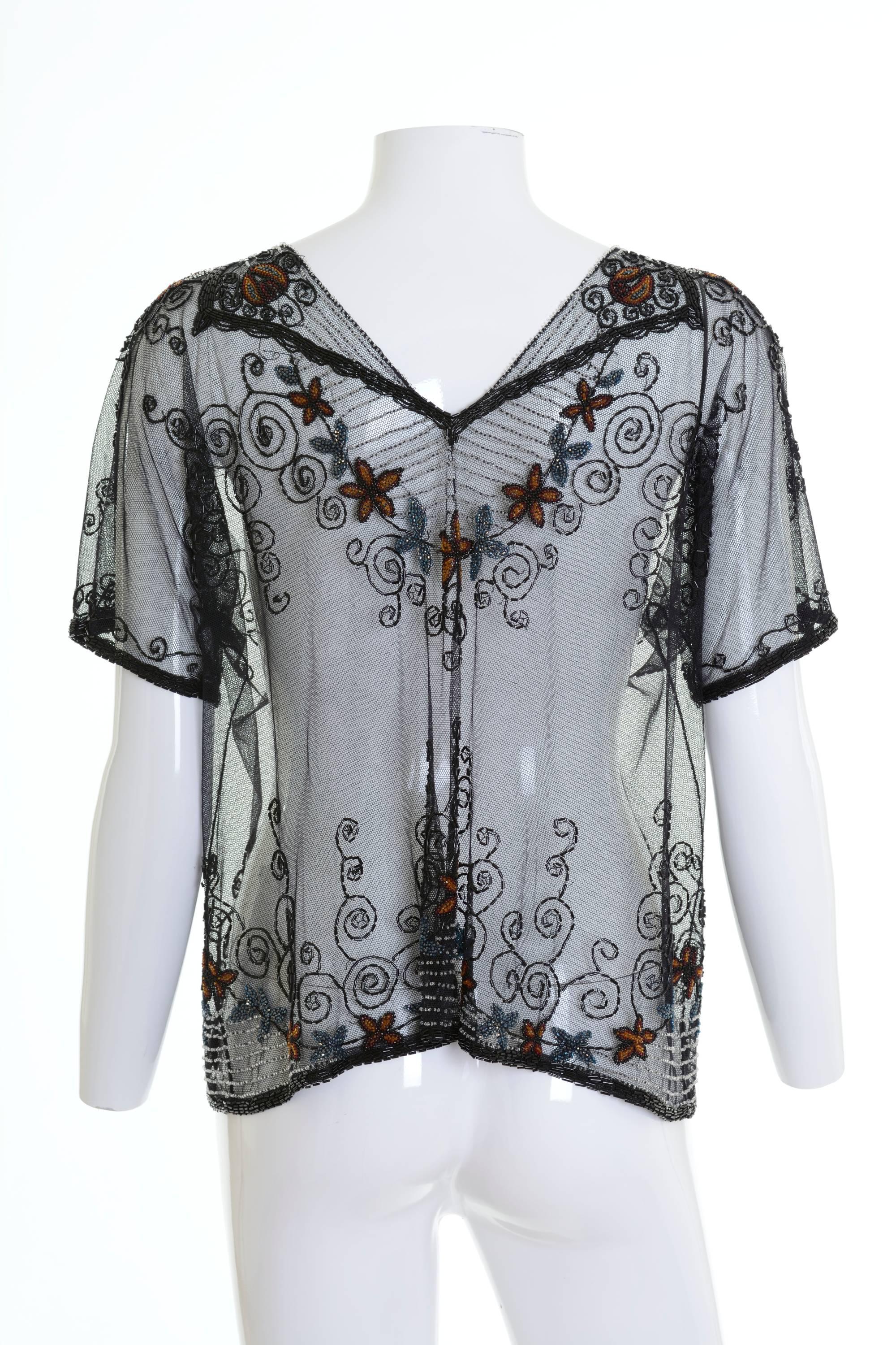 This amazing handmade 1920s blouse shirt is in a fabulous sheer tulle fabric with glass beadeds embroidered details. It has cap sleeves and straight line.

Excellent vintage condition

Label: N/A
Fabric: silk
Color: black

Measurement:
Estimated