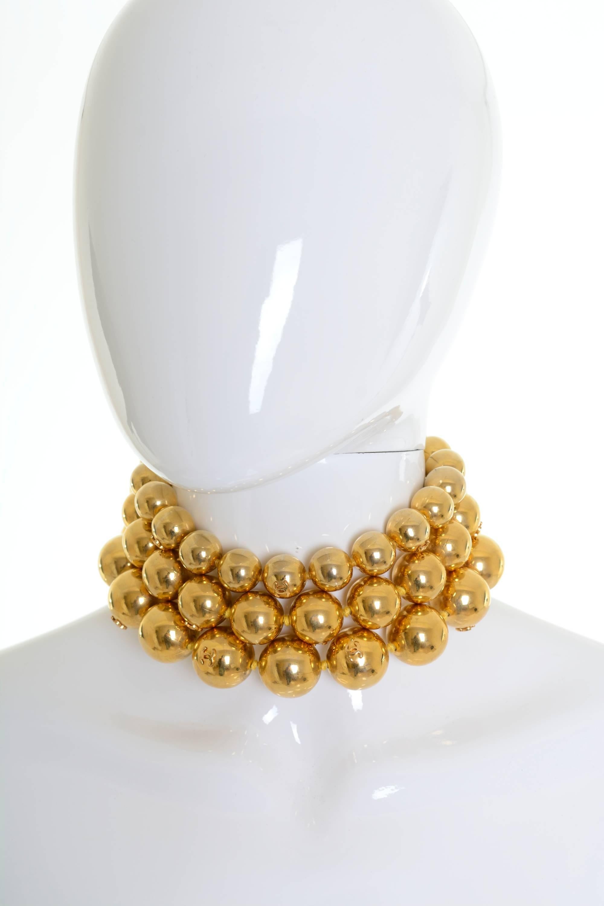 Authentic vintage Chanel Gold-Tone Beaded Triple Strand Choker Necklace. Featuring a triple strand of graduating gold plated beads with a double hook and eye closure and signature CC accents. Prepare to mesmerize and stand out in style with the