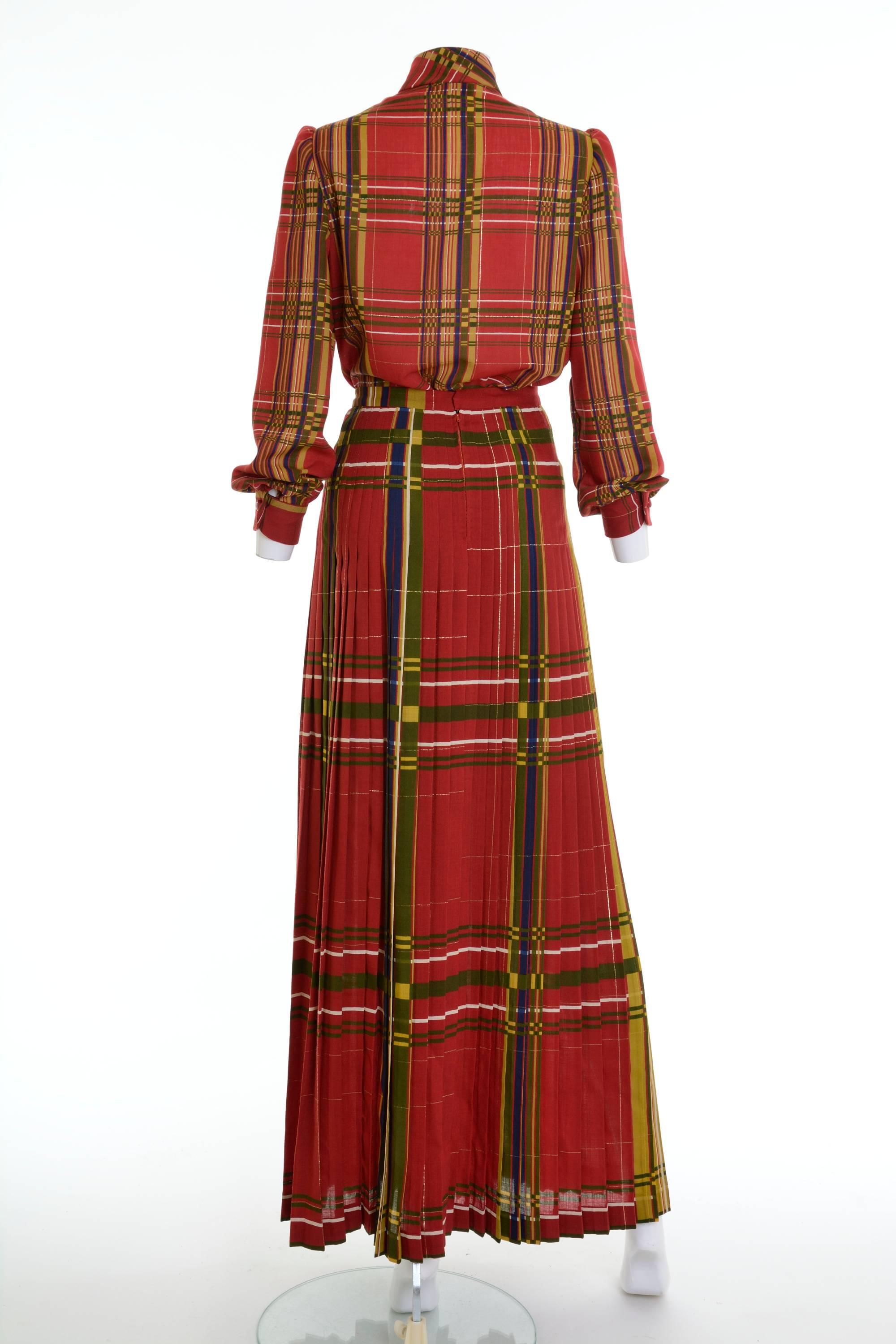 This lovely Valentino Boutique suit dress is in red and green tartan woolen fabric with lurex details. The shirt has mandarin collar, puffed long sleeves and plastic buttons closure. The long pleateds skirt has back zip and hooks closure.