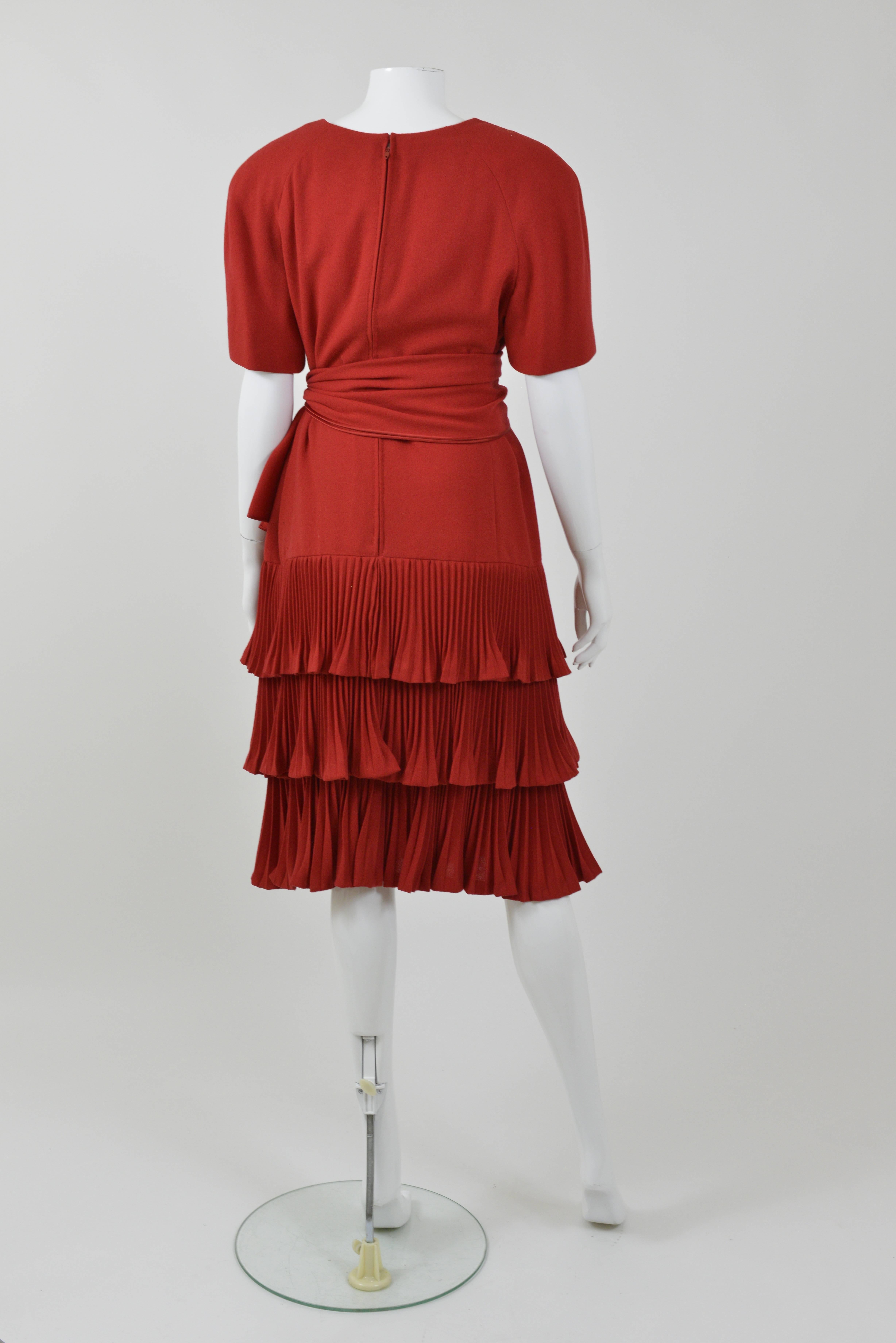 This lovely 1990s VALENTINO COUTURE Cocktail Dress is in red wool crepe fabric. It has padded shoulder and back zip closure. It's included a waist sash.

 Good Vintage Condition 

Label: Valentino Couture  
Fabric: wool
Color: Red 

Measurement