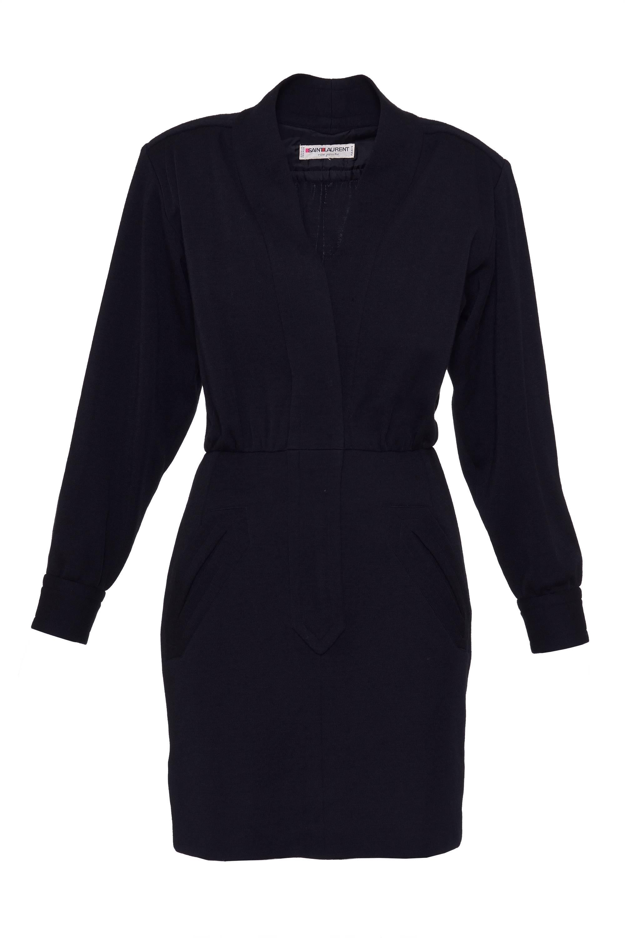 This lovely 1980s Rive Gauche black suit dress by YVES SAINT LAURENT has two front slashed jetted pockets, shoulder pads, V necklace, back horizontal yokes, long sleeves, buttoned cuffs, snap button, button, hook and bar closure on the top, and