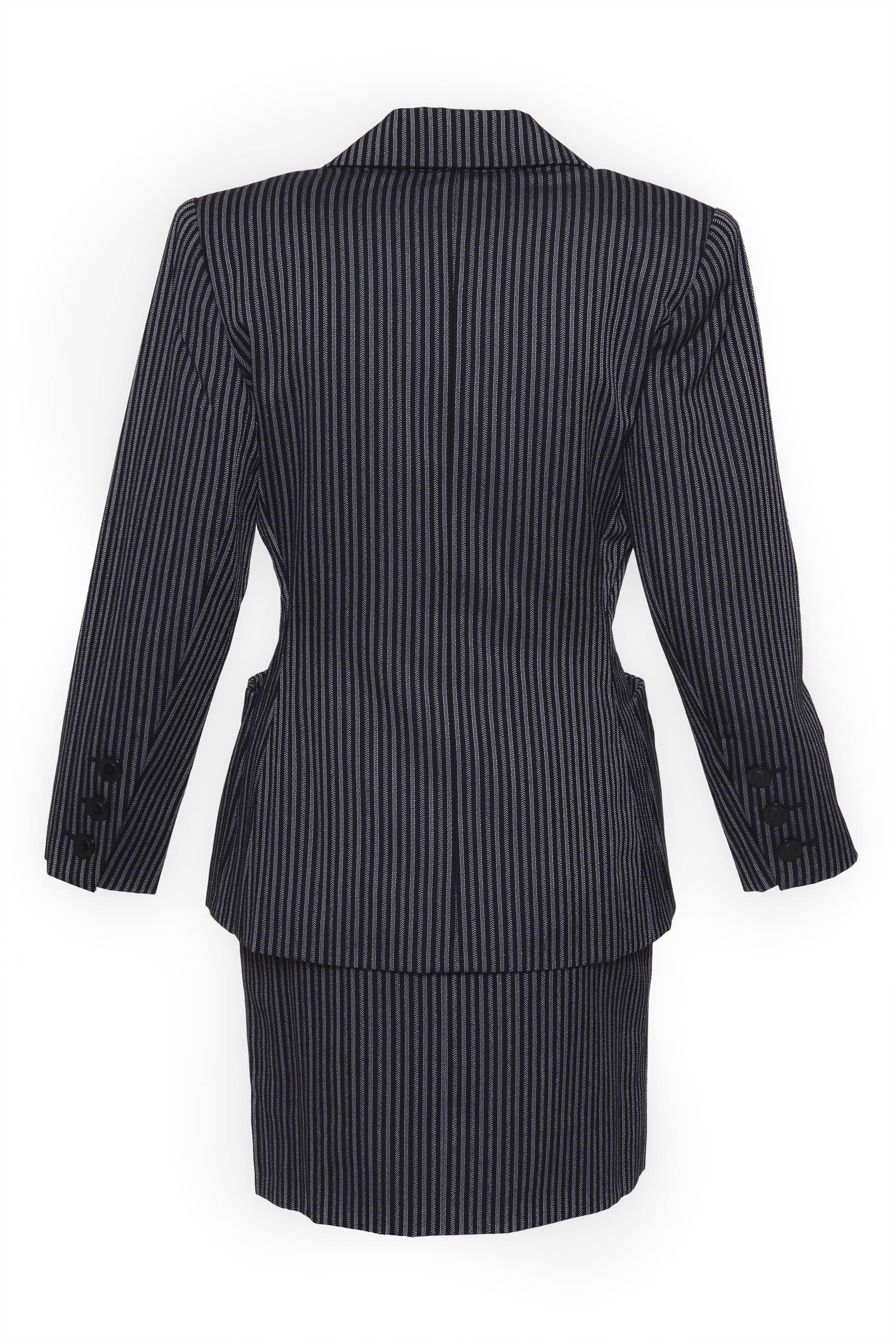 1980s Saint Laurent Rive Gauche in a pinstriped print wool gabardine fabric. The jacket has two frontal pocket and two front pocket, it is fully lined. The skirt has two frontal pocket, side zip and hook closure. In a skirt there is a lot of fabric