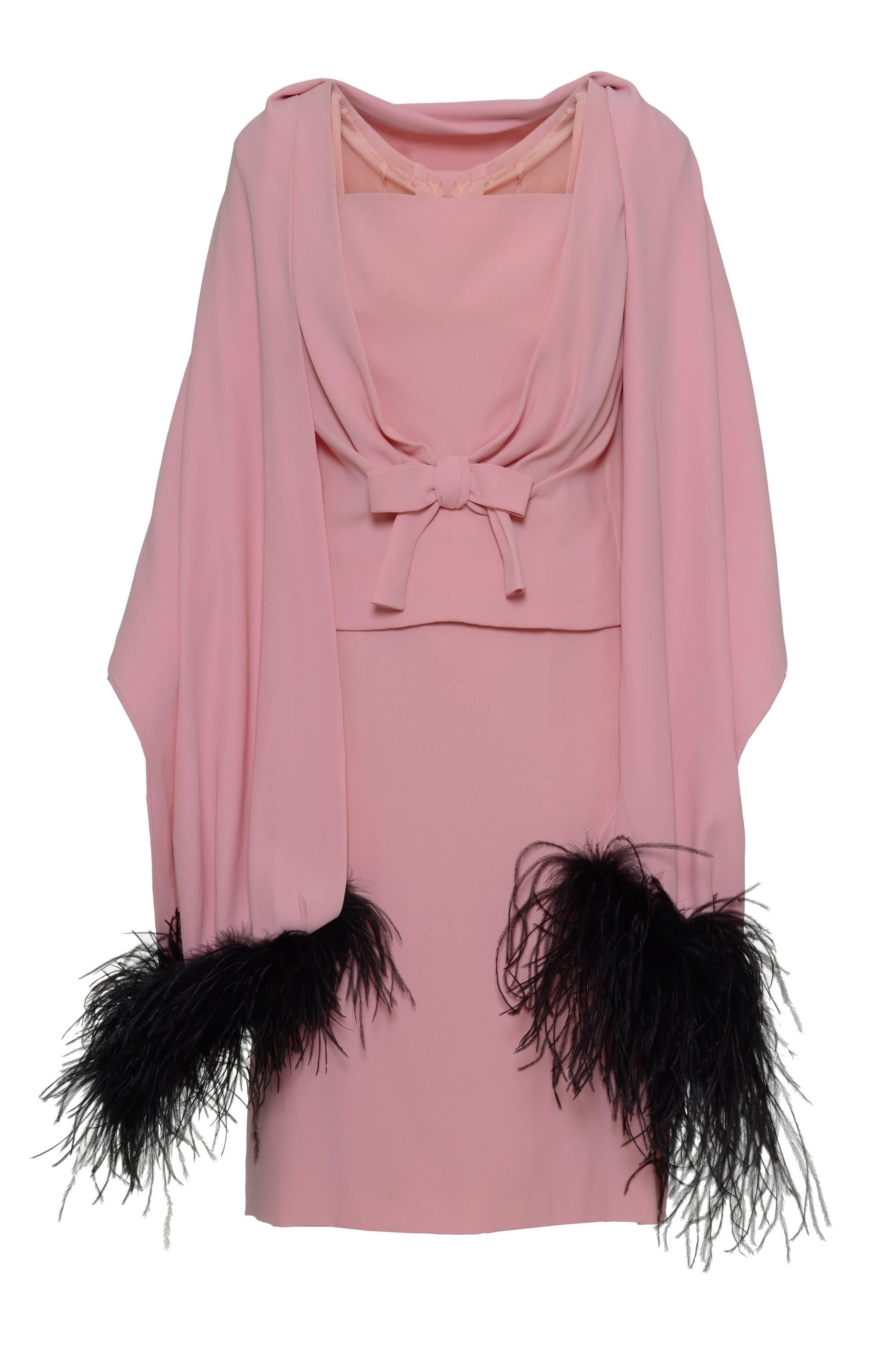 This 1960s pink cocktail dress has a back buttons closure on over-vest united with the skirt, two frontal darts, and a decorative bow on the same fabric. The stole has hems on black plumage.

Good vintage condition.

Color: Rose
Fabric: