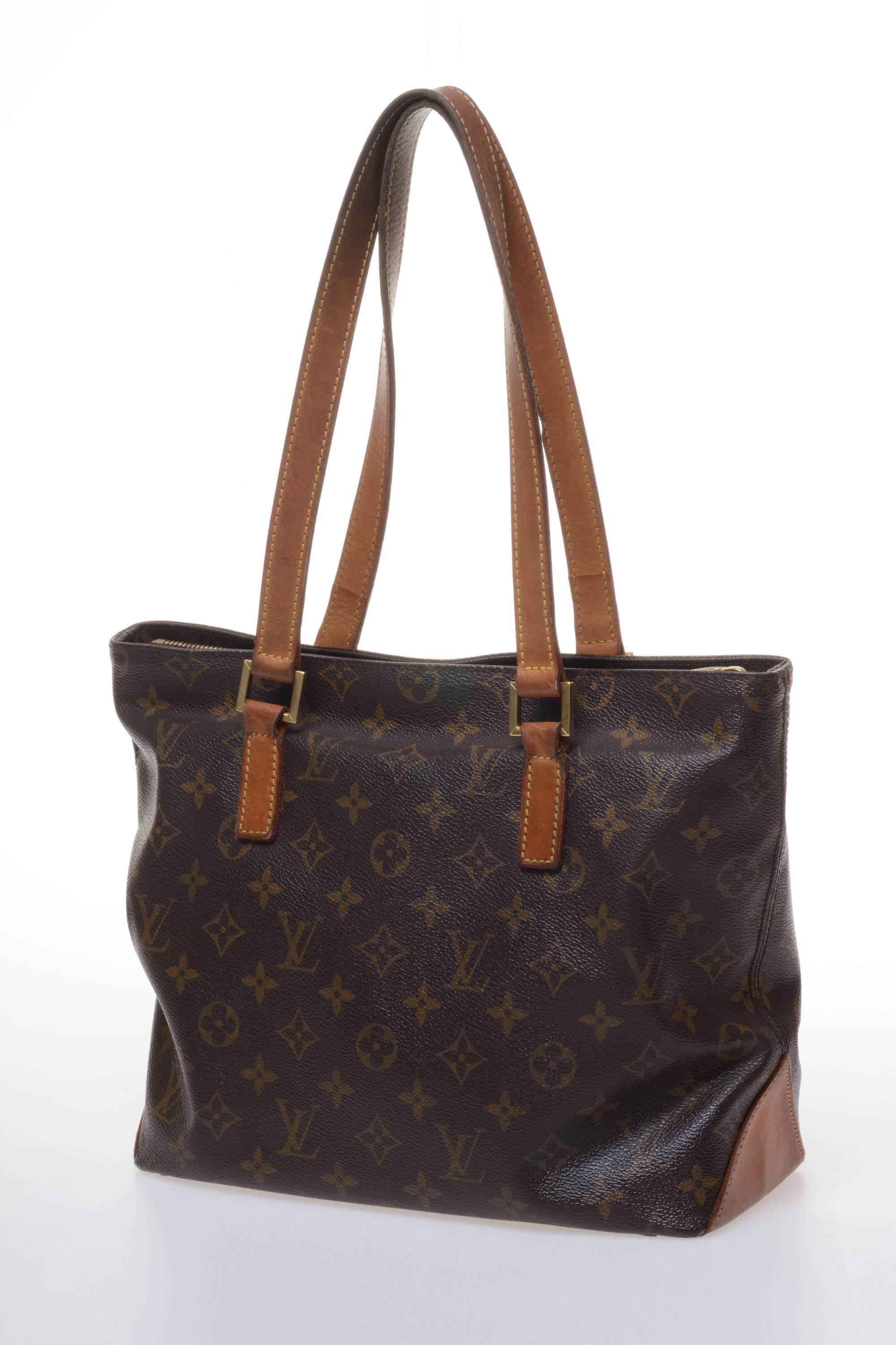 This handbag by LOUIS VUITTON has the monogram print and 1970s shape style, a pocket inside with zip closure, a cell phone pocket and a ring-keys, and old gold details such as the square handle attachment. It is fully lined in cotton, and strong