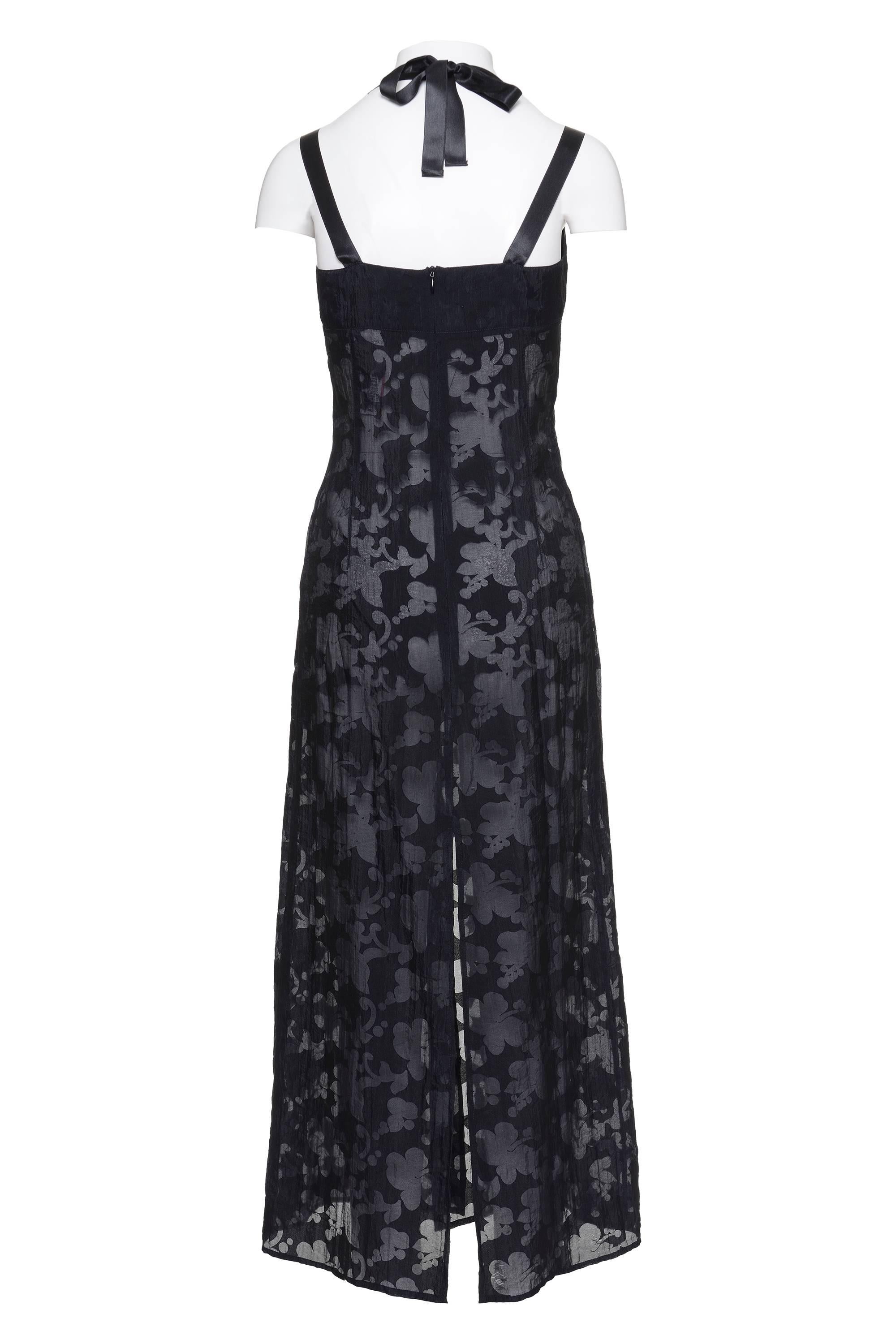 This lovely black sheer dress made of silk organza by JOHN RICHMOND has an adjustable lace to adapt on the shoulders, front and back vents, a horizontal decorative cut on the bust, and back invisible zip closure. The textile has been made with a
