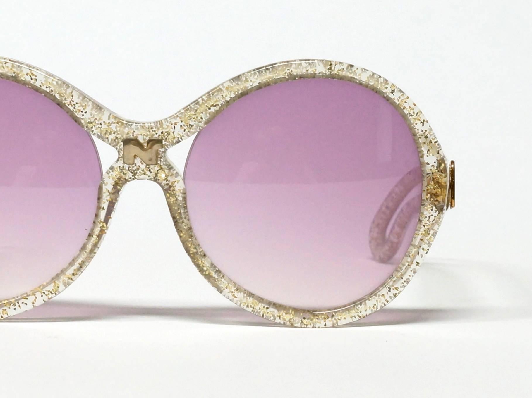 Amazing vintage 70s Nina Ricci sunglasses. Gold and Glitter translucent oversized frame with cutout details and logo at bridge and carved arms arms with golden logos. 

approximate dimensions: 
temple length: 135 mm - 5 5/16