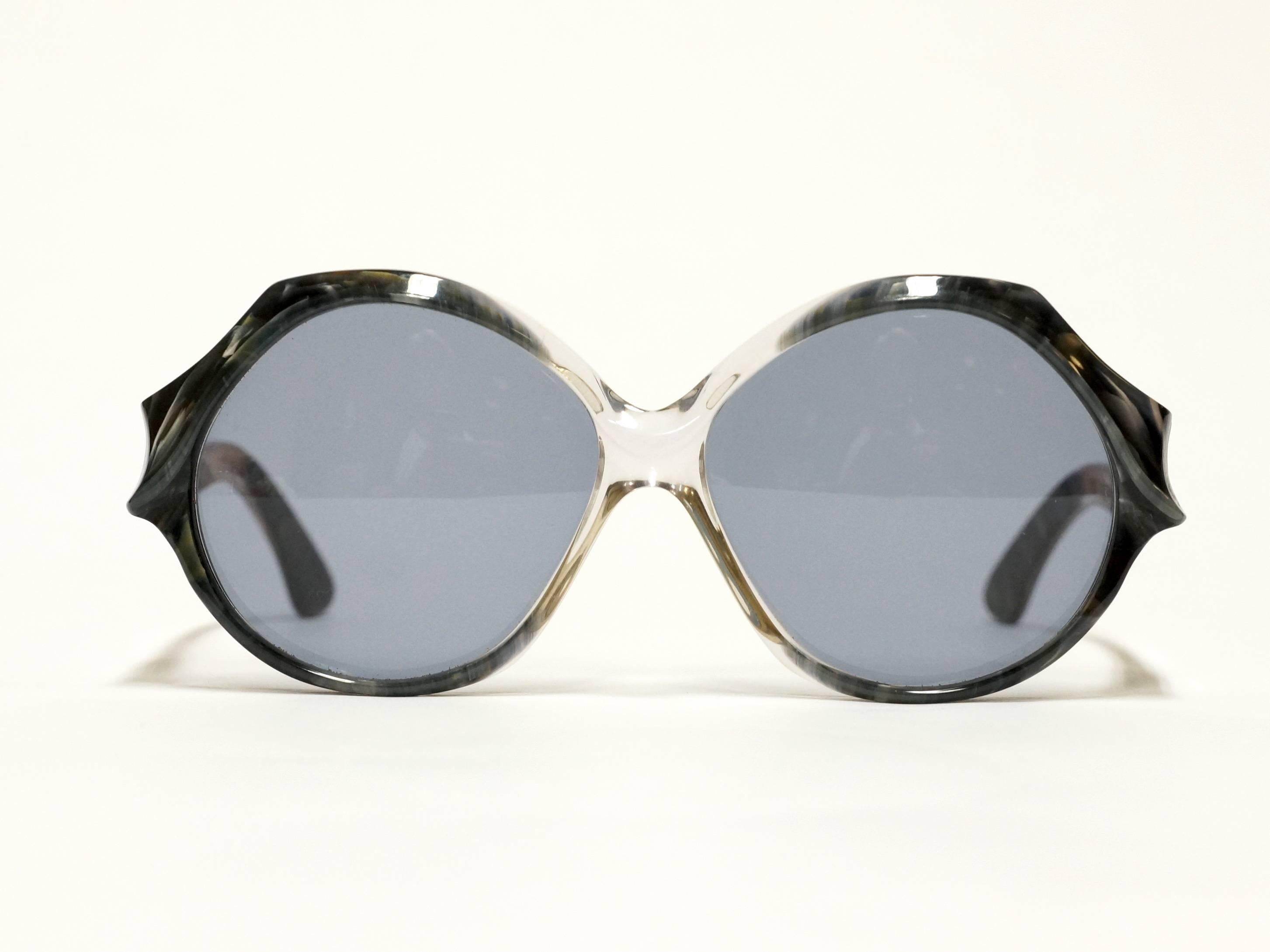 1970s French vintage sunglasses by Jacques Fath. Round acetate frame, dark gray on the sides, becomes almost transparent in the middle. 

Model: Esterel/7
size: 54▢18 -125

approximate dimensions:
temple length: 125mm - 4 14/16