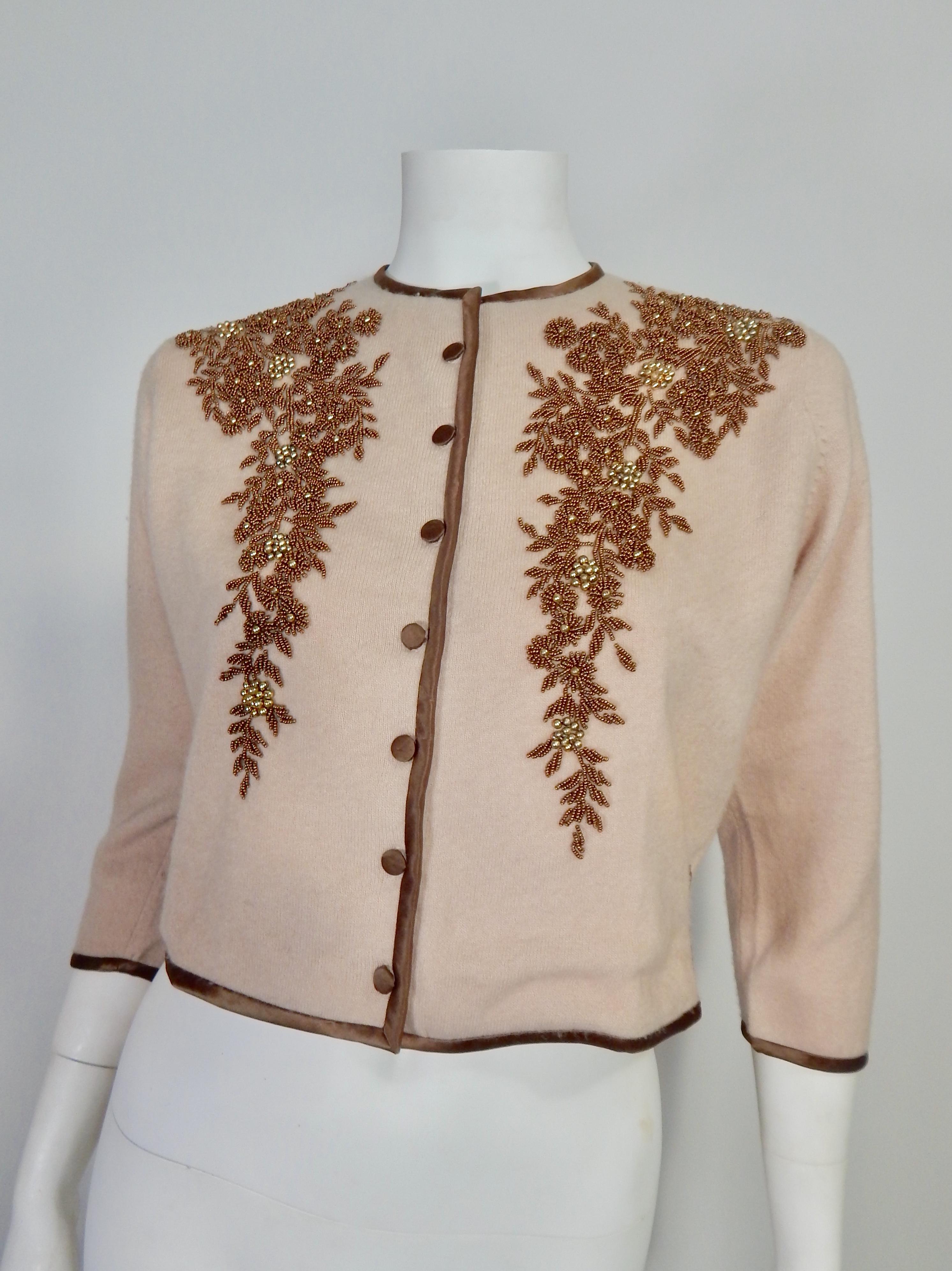 1950s Cashmere Beaded Cardigan with Silk Buttons and Trim. Light mocha color with chocolate brown silk trim and buttons. Brown and gold metallic beading.  Fully Lined in light mocha colored silk. Tag Reads Duke of Scott 100% Cashmere 
Domestic US