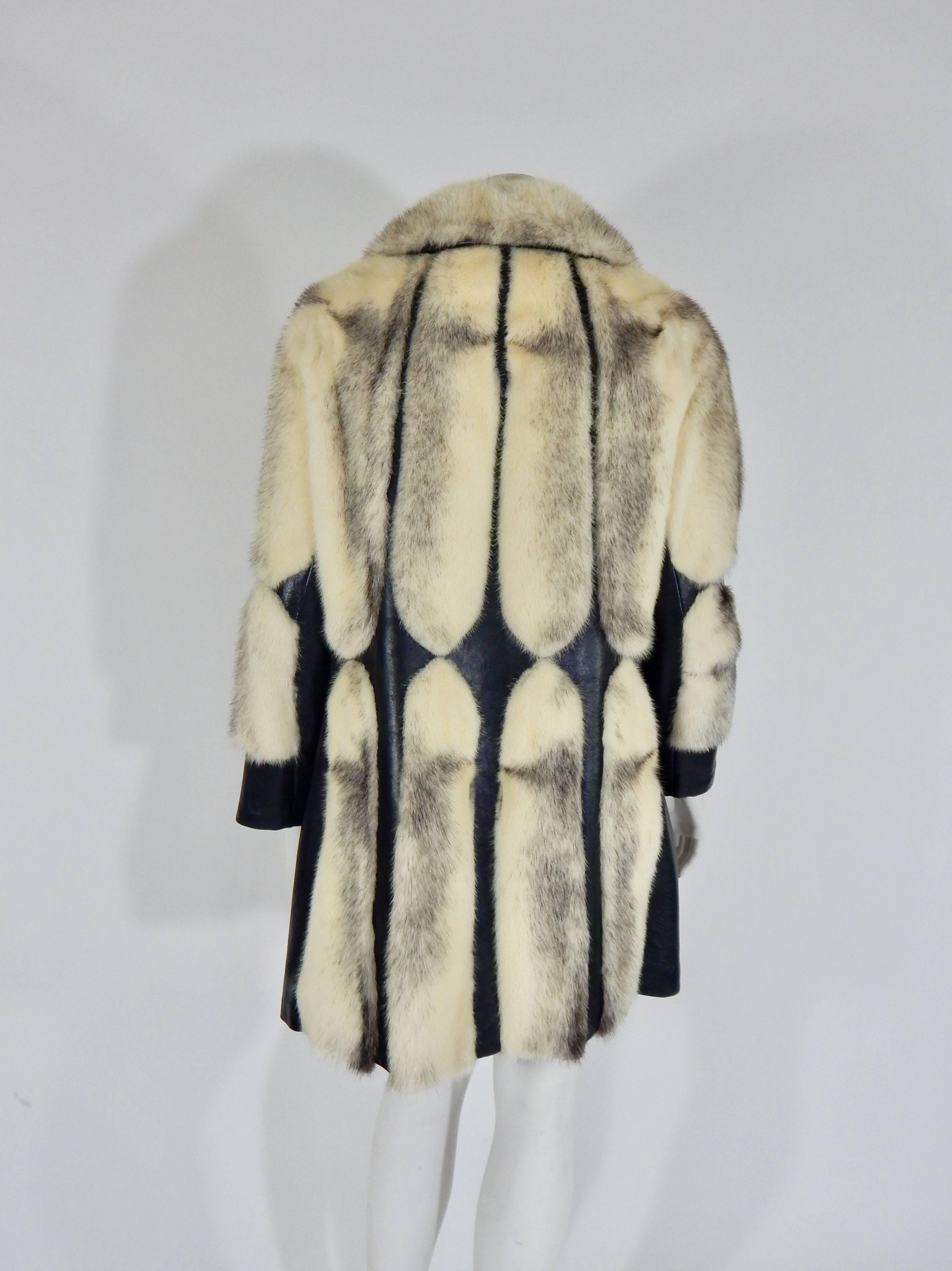 1960s Cross Fur Mink and Leather Coat. Black Leather design throughout. Leather Tie belt is not exposed in back of coat for complete view of design. This also allows for flexibility of waist size. Snap closures down front. 
Garfinckel Tag. 
Black