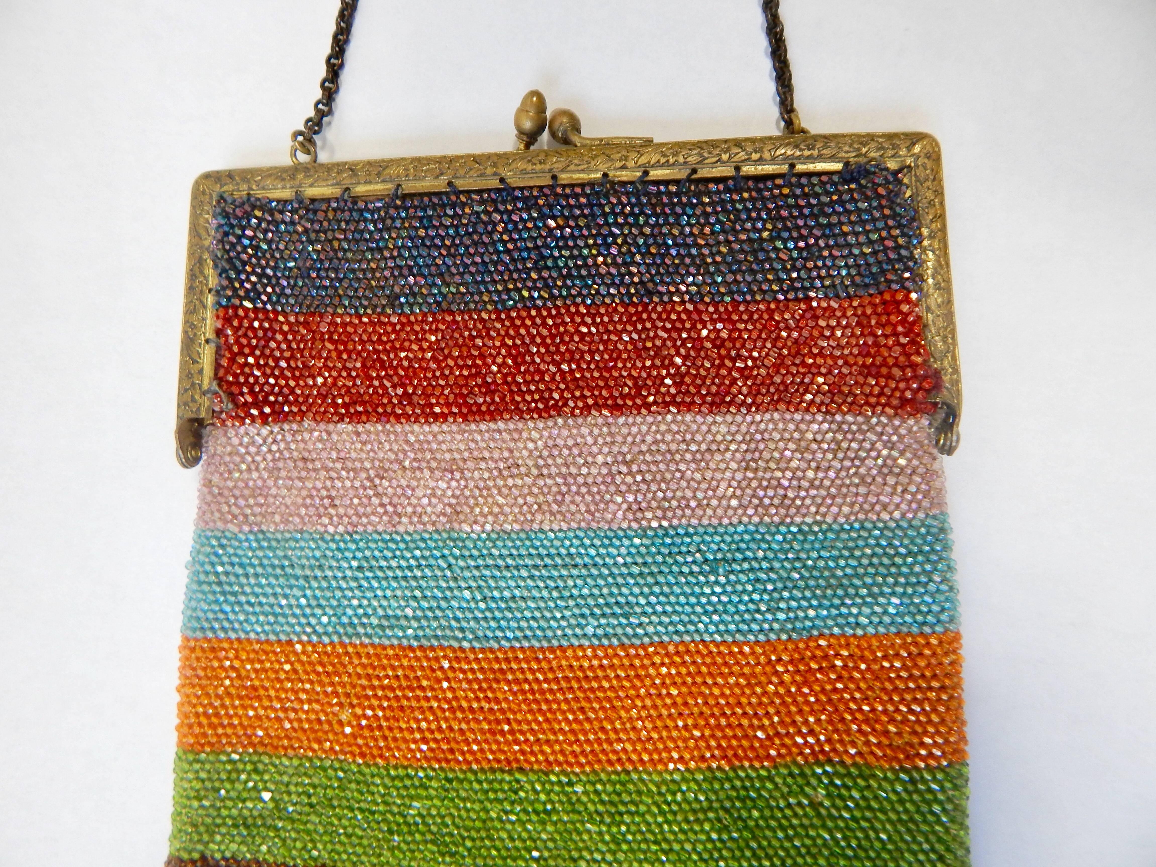 Unique multicolored brightly striped design with multicolored fringe. Entire purse is beaded with ornate antique gold hardware. Clasp closure and hand chain. 