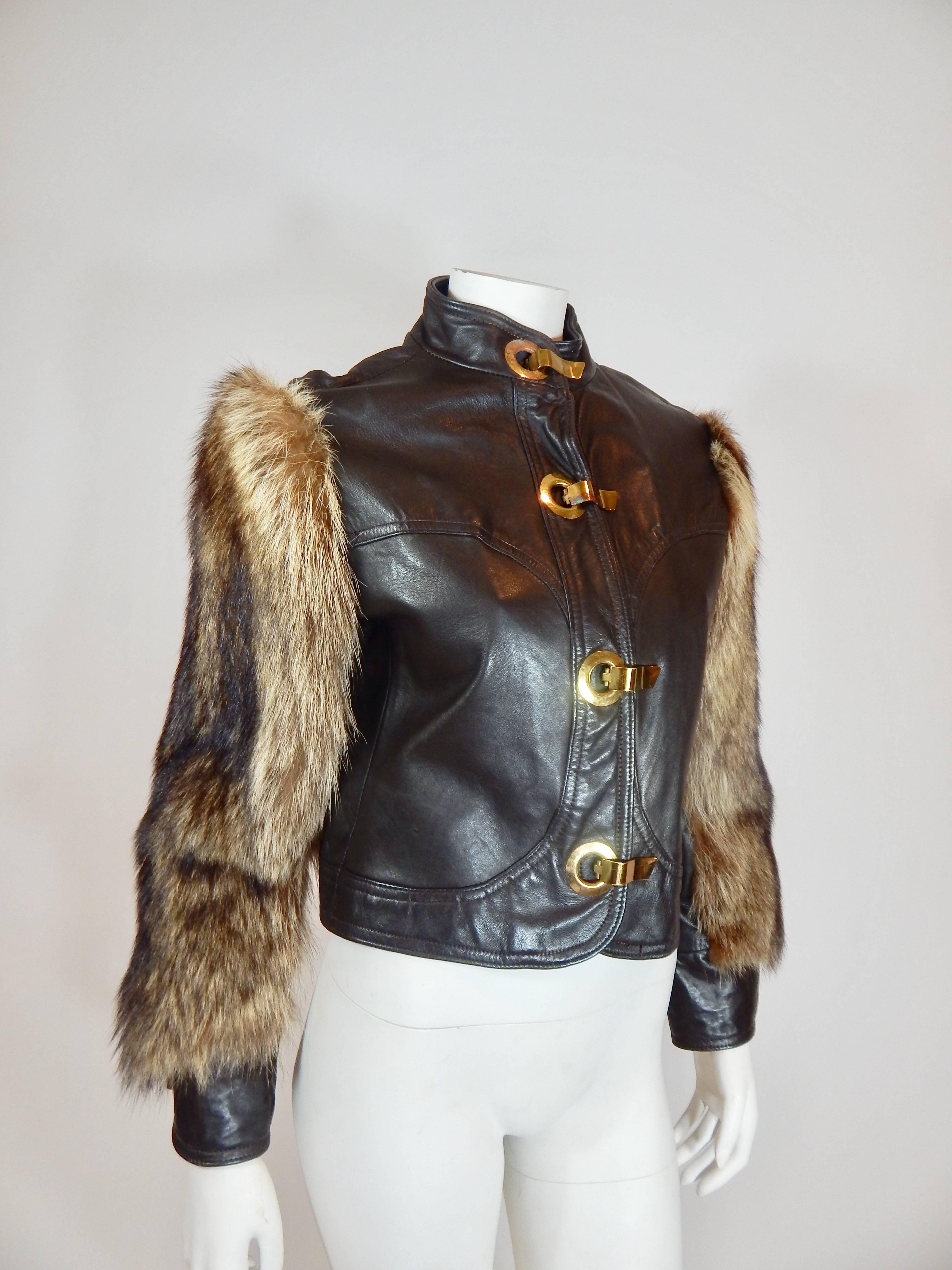 1970s Chocolate Brown Leather. Raccoon Fur Sleeves. Brass buckle clasps in front and cuff. Leather and Fur are both  in Excellent Condition. The brass clasps exhibit some age with some tarnish. See photo. Interior is Dark brown and exhibits some