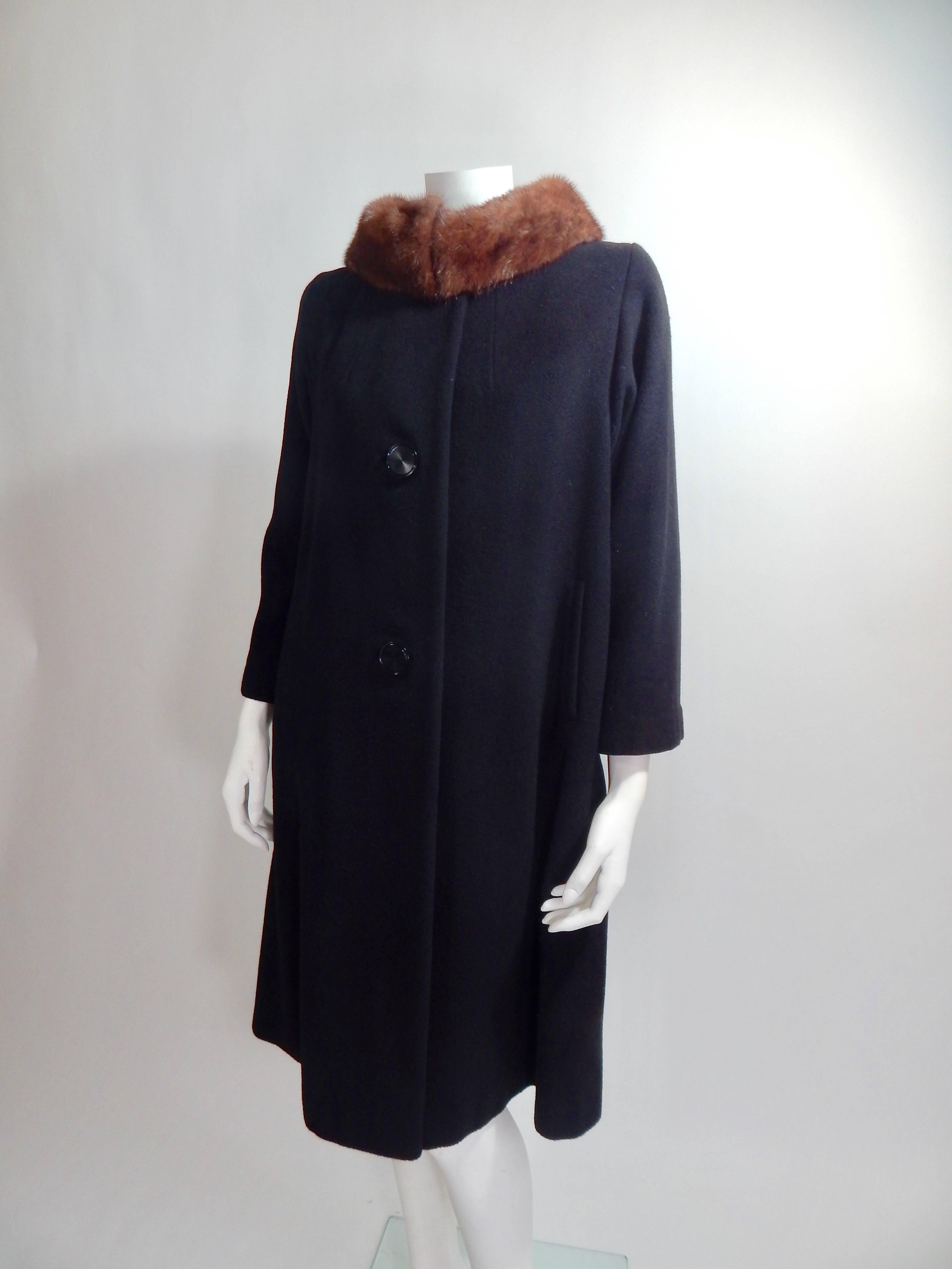 1950s 100% Cashmere Coat with Brown Mink Fur Collar. Large Black Buttons in front. Fully lined in black Silk. Interior and Exterior are both in Excellent Condition.
Approximate size 8.