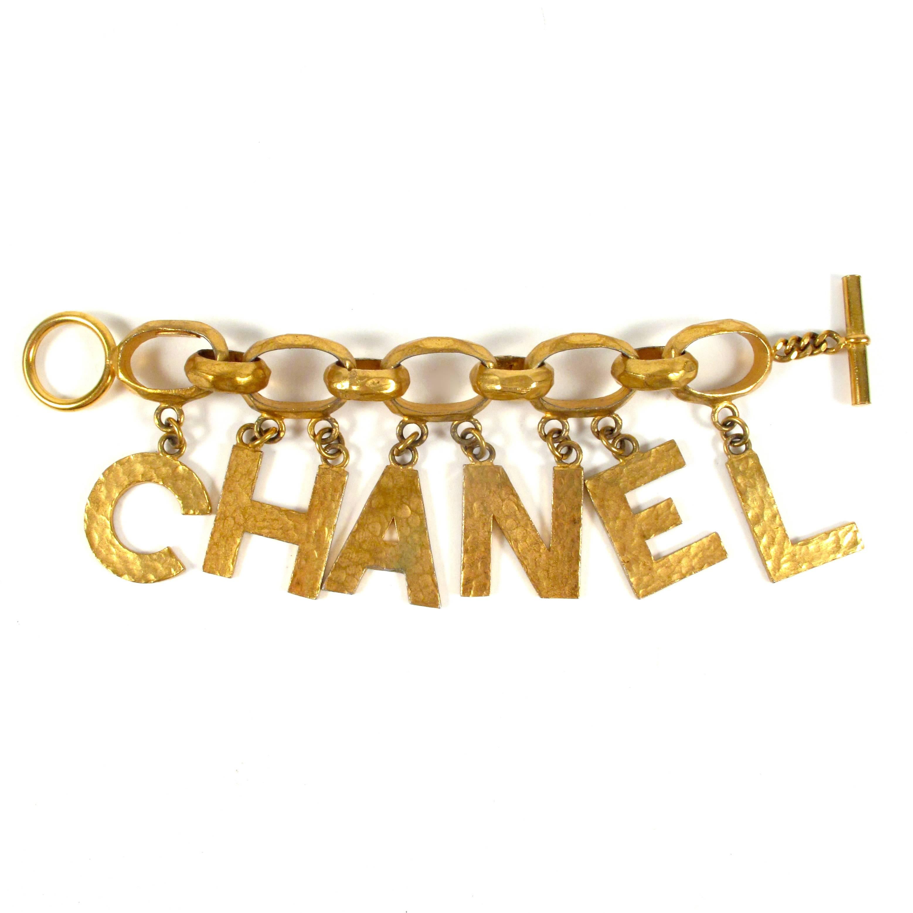 Chanel - Logo Charm Bracelet

Color: Gold

Material: Metal 

------------------------------------------------------------

Details:

- gold tone hardware

- chanel letter charms

- textured metal

- stamped 93P from the spring 1993