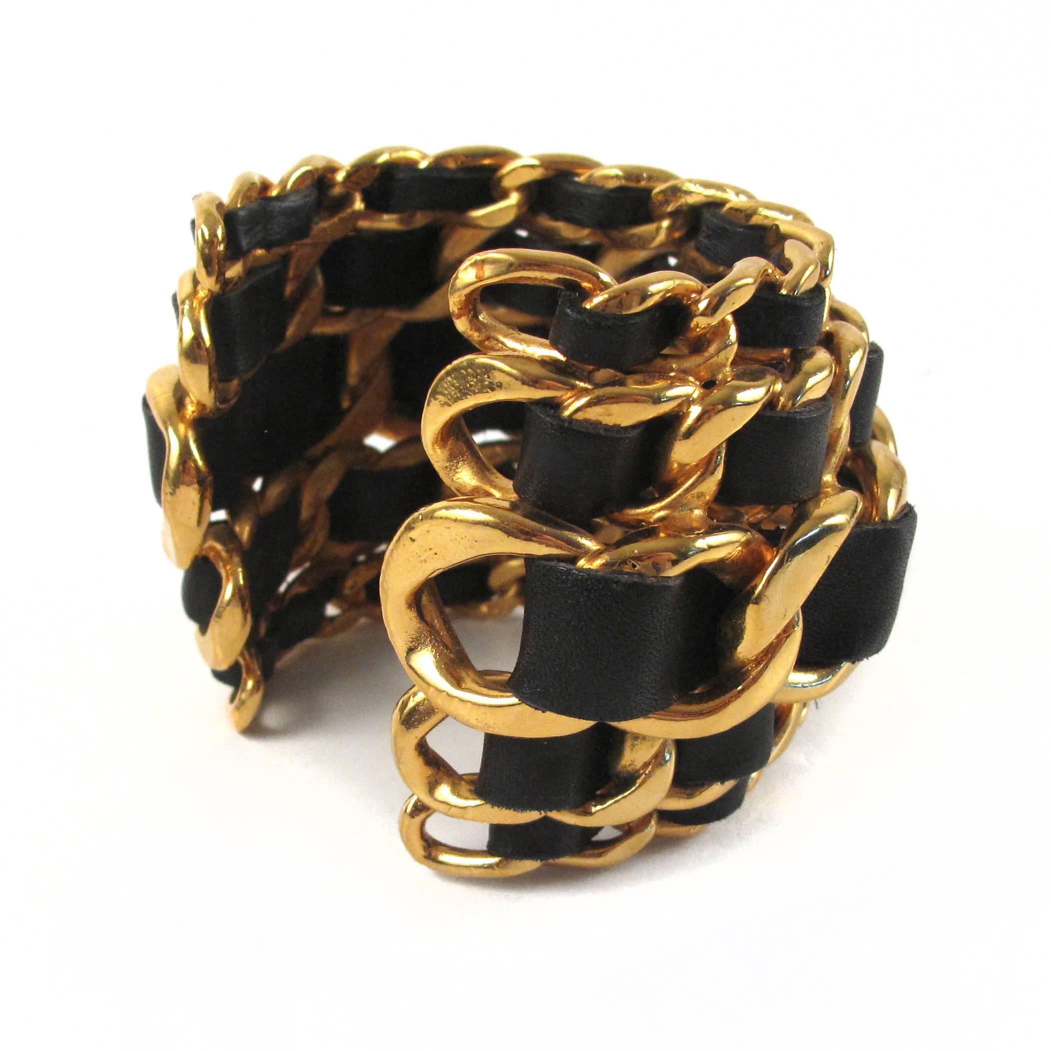 Chanel - Vintage Woven Wide Chain Cuff

Color: Black / Gold

Material: Leather / Metal 

------------------------------------------------------------

Details:

- gold tone hardware

- black woven leather

- stamped 26 - from