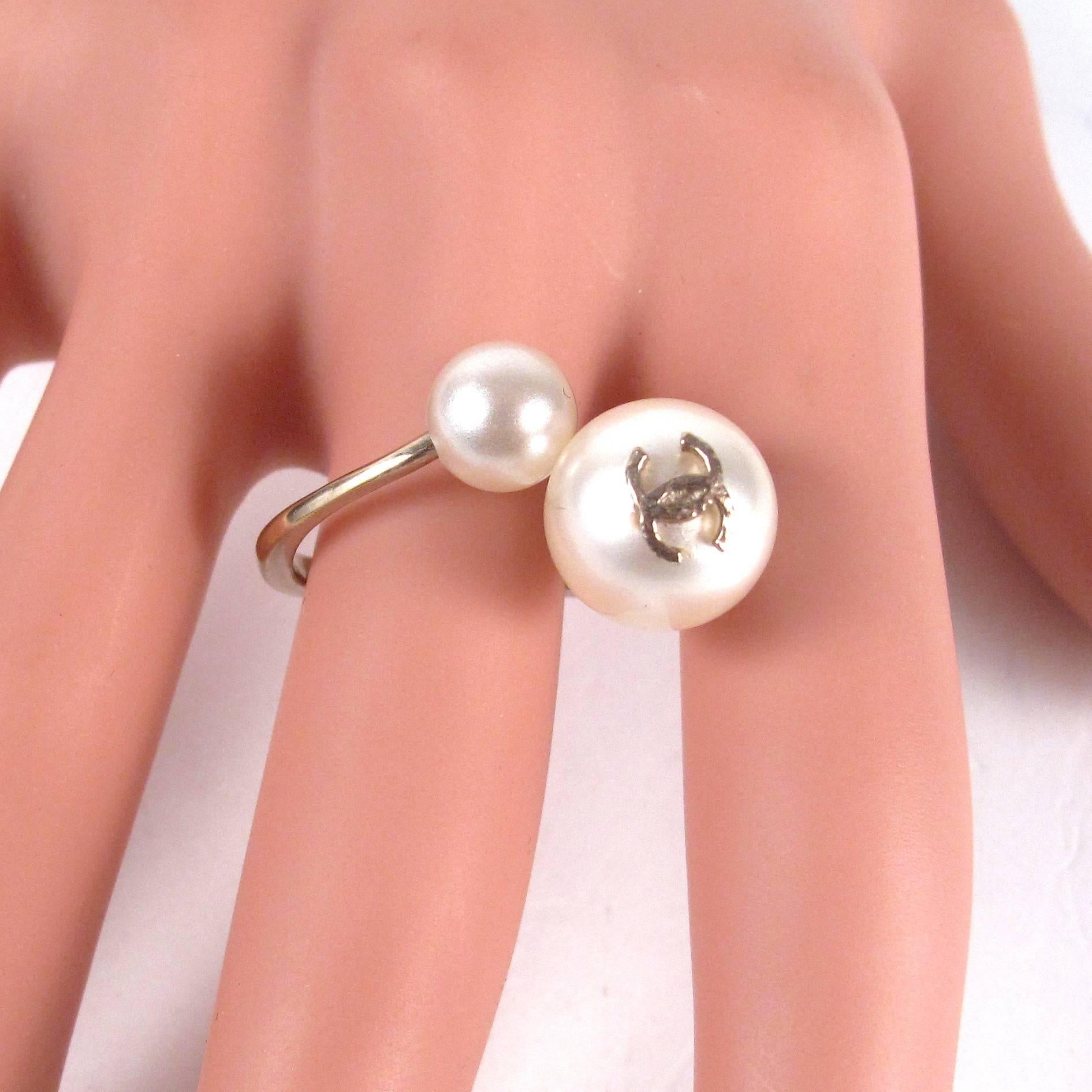 Chanel - Double Pearl Ring

Size: US: 6.5 - French Size: 52 & 3/4

Color: Gold

Material: Metal / Pearl (Imitation)

------------------------------------------------------------

Details:

- gold tone hardware

- large & small pearl