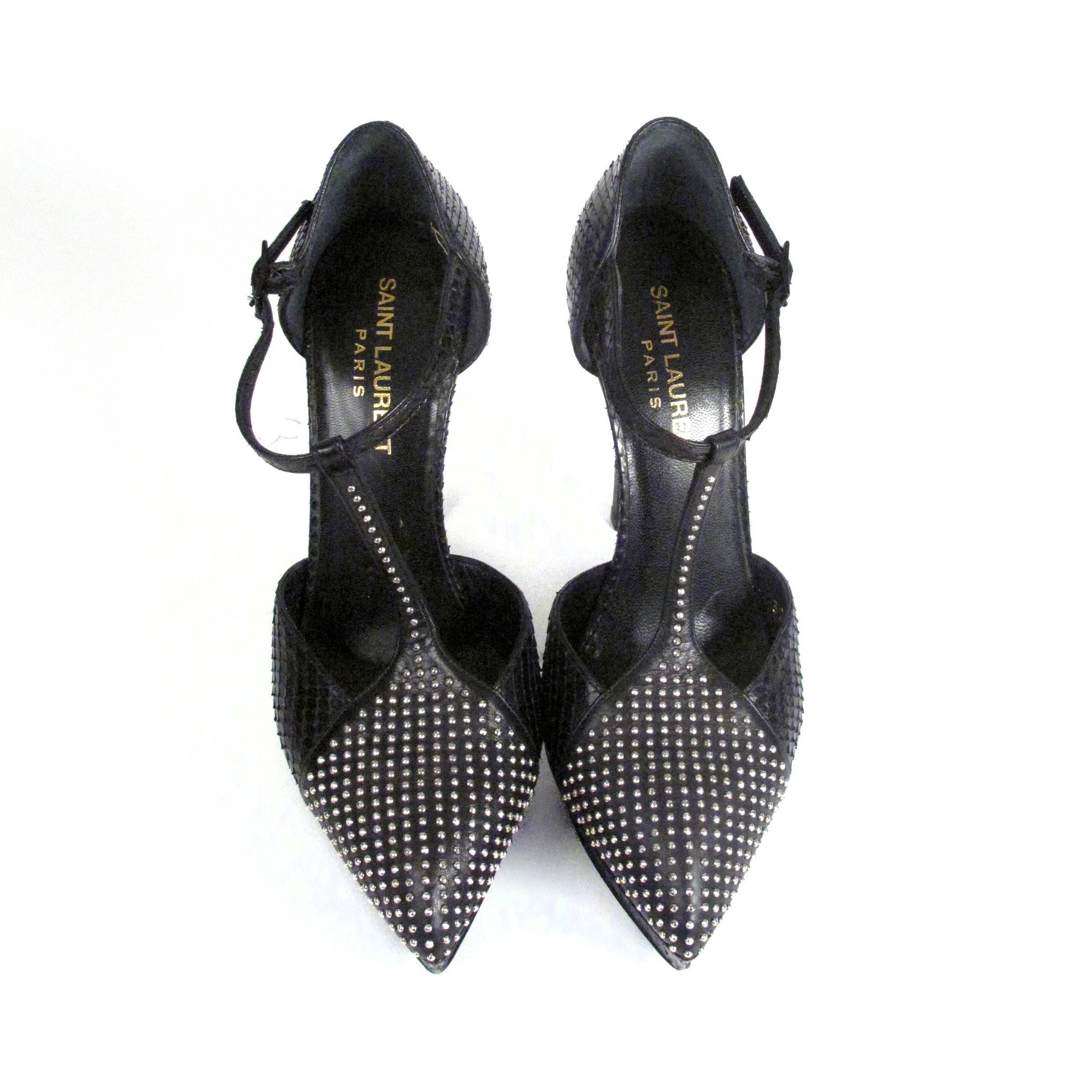 Saint Laurent - Janis - Python Studded Strap Heels

Retail: $2000.00

Size: US 6 - 36

Color: Black

Material: Leather & Metal

------------------------------------------------------------

Details:

- silver tone studs at toe

-