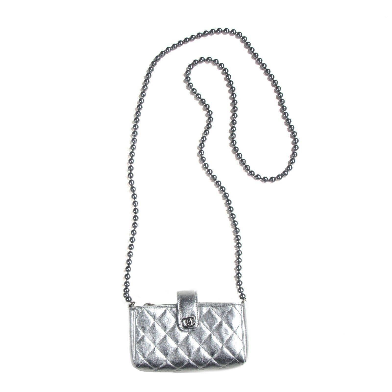 Brand New:

Chanel - O-Case Shoulder Bag

Color:  Silver

Material: Leather
 
------------------------------------------------------------
 
Details:
 
- silver tone hardware

- long crossbody pearl beaded strap

- quilted leather

- cc logo