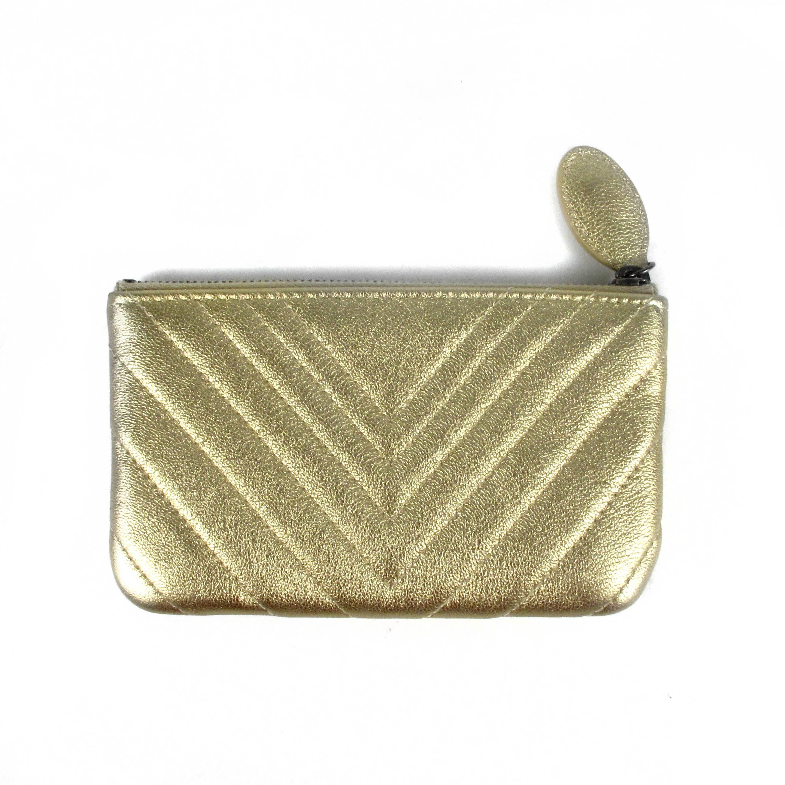 Chanel - Chevron Small Clutch Bag

Color: Metallic Gold 

Material: Leather

------------------------------------------------------------
Details:

- chevron quilted leather

- gunmetal hardware

- CC logo at front

- zip top closure

- serial