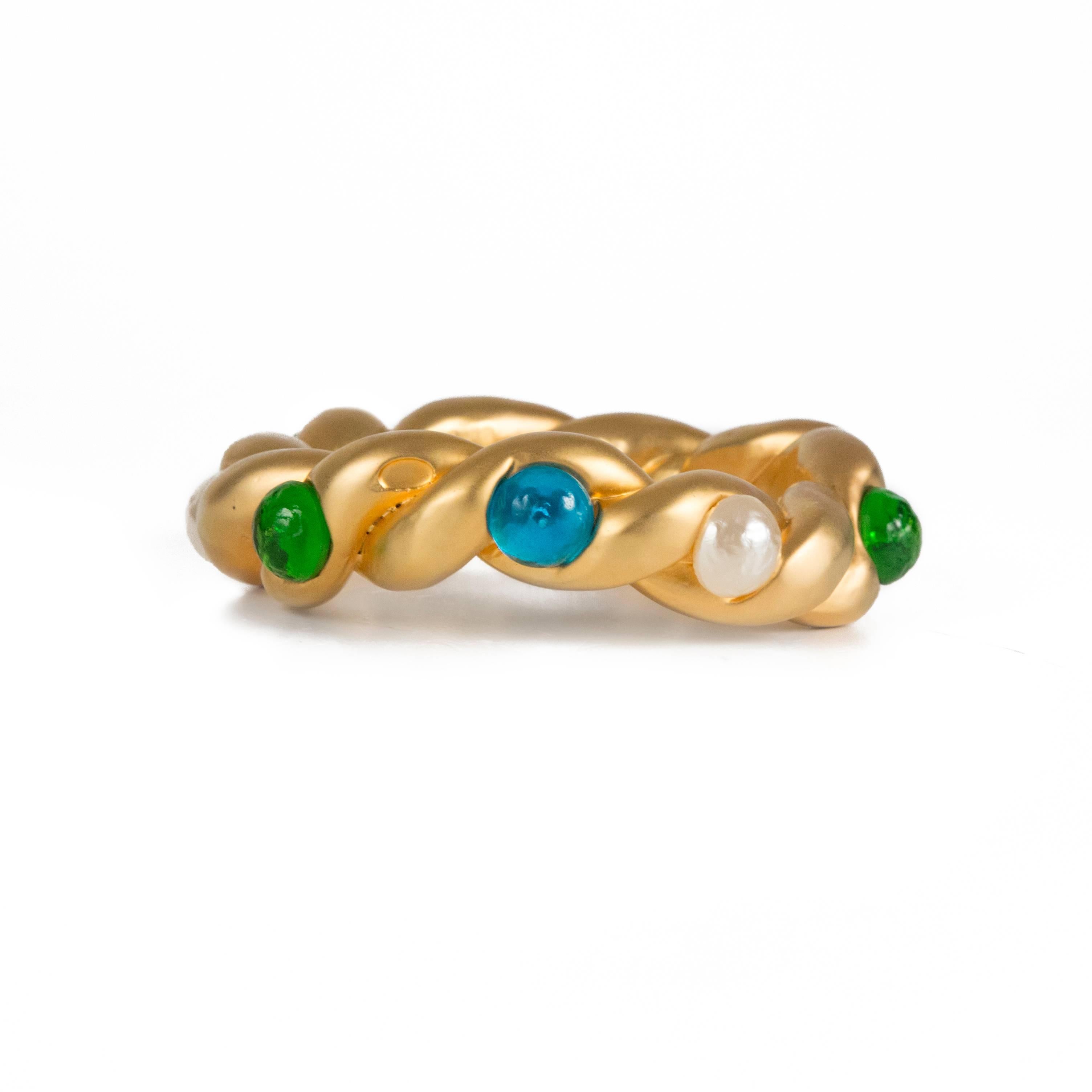 Chanel - Gripoix & Pearl Gold Bangle

Color: Gold

Material: Metal

------------------------------------------------------------

Details:

- gold tone hardware bracelet

- pearl beads throughout

- green & blue glass stones