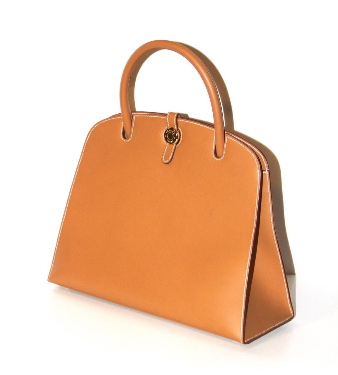 Elegant and sophisticated bag from Hermès with classic rigide shape, simple but strong look. This bag is very hard to find. Natural Chamonix leather Hermès, gold hardware, single rolled handle, white stitching, three interior wall pockets and Clou