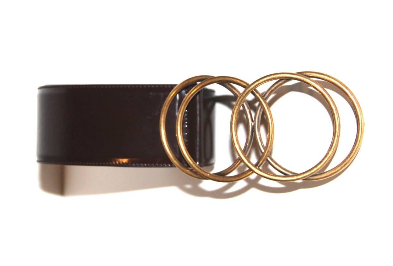 This fancy Yves Saint Laurent's brown glossy leather wide belt features a metal rings buckle, an antique gold-tone hardware, a tonal stitching and an adjustable fit. 

Collection: Vintage, 90's
Fabric: Glossy leather
Color: Brown
Size: