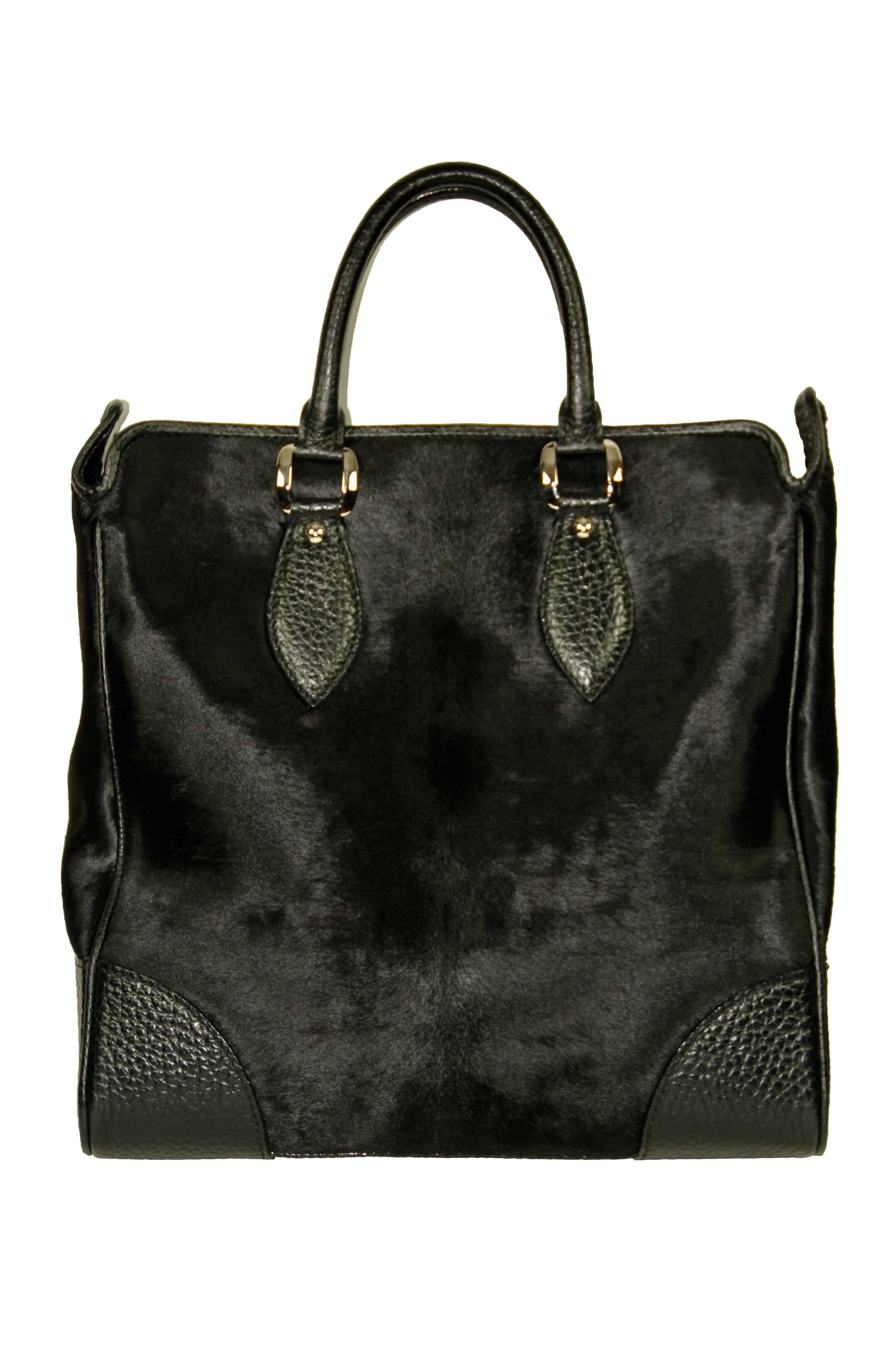 Amazing and structured tote bag from listed edition 2006 men runway collection. It is made of Naxos leather and spawn fur.   

Year: 2006 
Material: Grained leather, pony hair 
Color: Black 
Hardware: Polished silvertone 
Measurements: L 55 cm x H