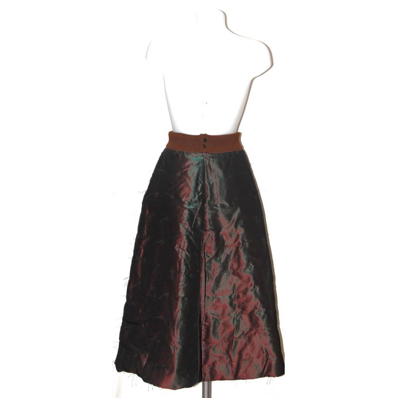 This standout A-line skirt from Chanel is the perfect piece to get in the wardrobe. The amazing color features an iridescent effect, brown and green. The  brown embroidered stitch details throughout give a delicate final touch. 

Collection: Fall