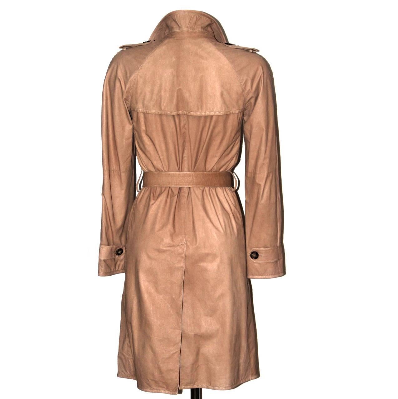 This chic Prada trench is perfect for transitioning between seasons. Crafted from soft paper thin lambskin leather, this classic double-breasted trench is detailed with shoulder epaulettes. Use the detachable belt to define your feminine