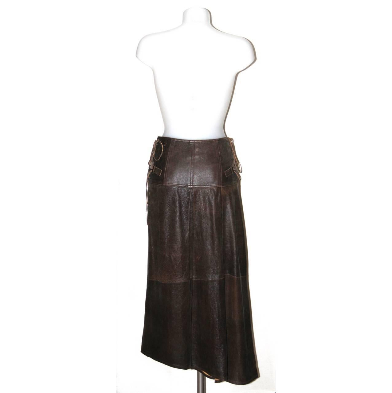 Gorgeous brown leather skirt. A signature style by John Galliano for Christian Dior featuring an A-line wrap design with side antique-gold tone metal buckles and hip laces, two front buttons closure and a box pleat on the back. 

Collection: Late
