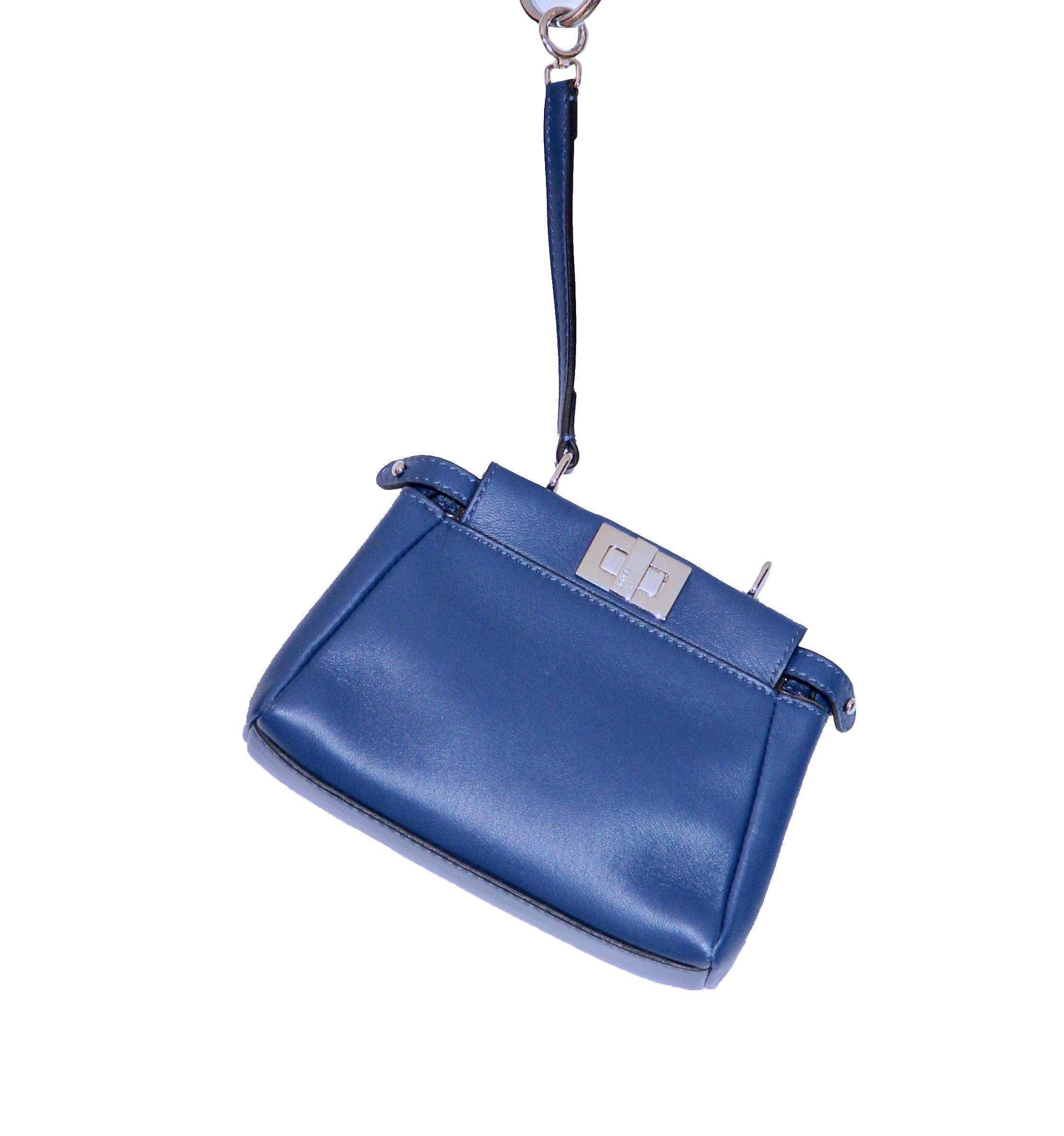 Charming pre-owned Micro Peekaboo bag in a soft blue Nappa leather featuring 2 inner compartments divided by a partition with twist lock and magnetic button. 
Single handle with spring clip on one side and a long thin adjustable, removable shoulder